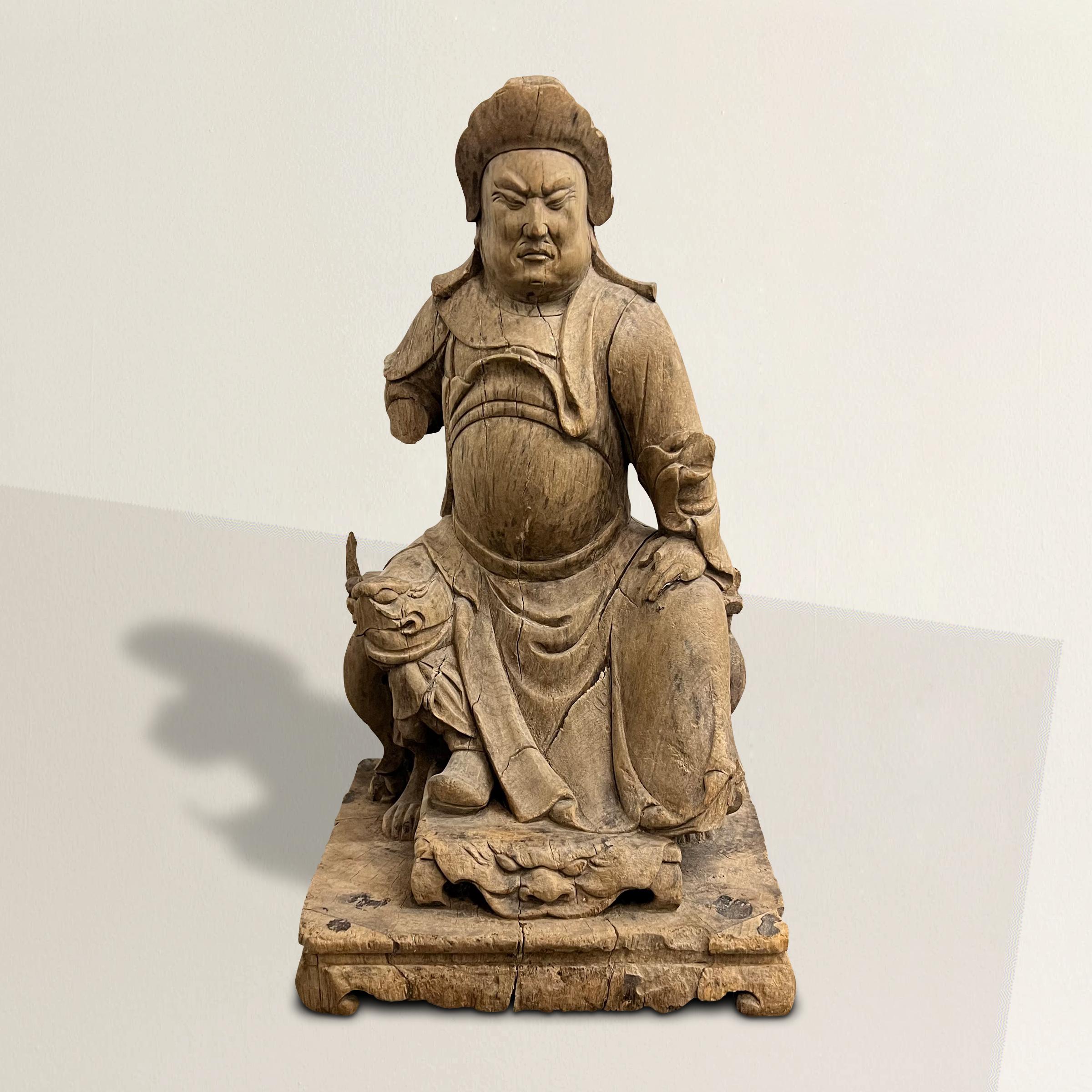 Maravíllate ante el exquisito arte de esta figura de antepasado tallada en madera de la dinastía china Ming (1368 a 1644), una cautivadora representación de un hombre sentado ataviado con el distinguido atuendo de un funcionario del gobierno.