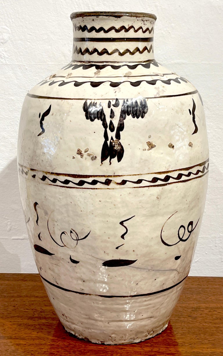 Ming Dynasty Cizhou stoneware vase #1*
China, circa 17th Century or older
A fine tall example, hand decorated in typical earth-tone Chinese calligraphic palette. 
This vase stands 23-Inches high x 13-Inch diameter, raised on a 8-Inch diameter