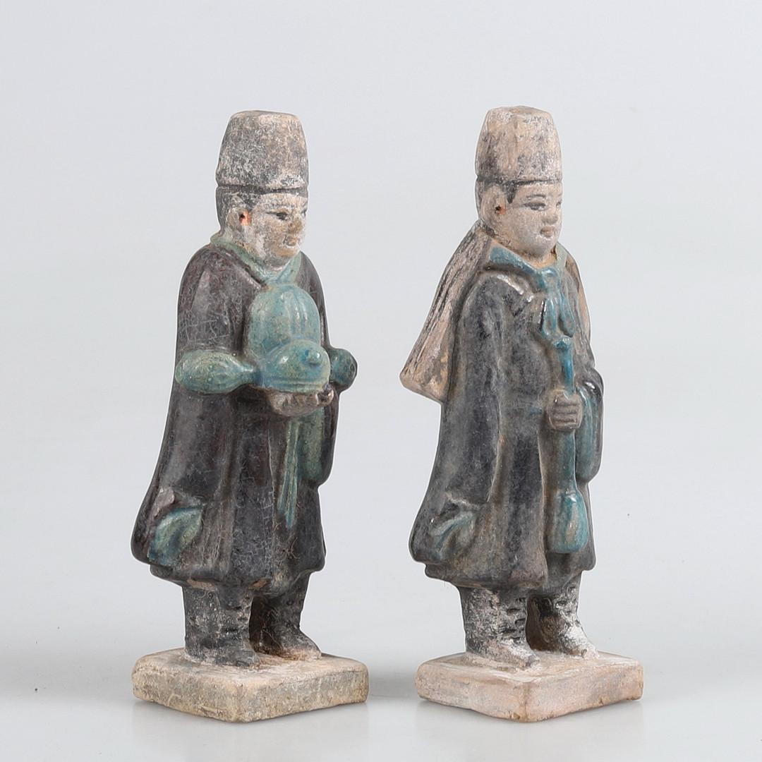 Pair of Chinese green glazed pottery statues, Ming Dynasty (1368-1644).
Comprising two male attendants, wearing long robes and hats, standing on square stepped bases. Glazed and painted in blue, turquoise, red and black.

Measure: height 16.5 cm.
