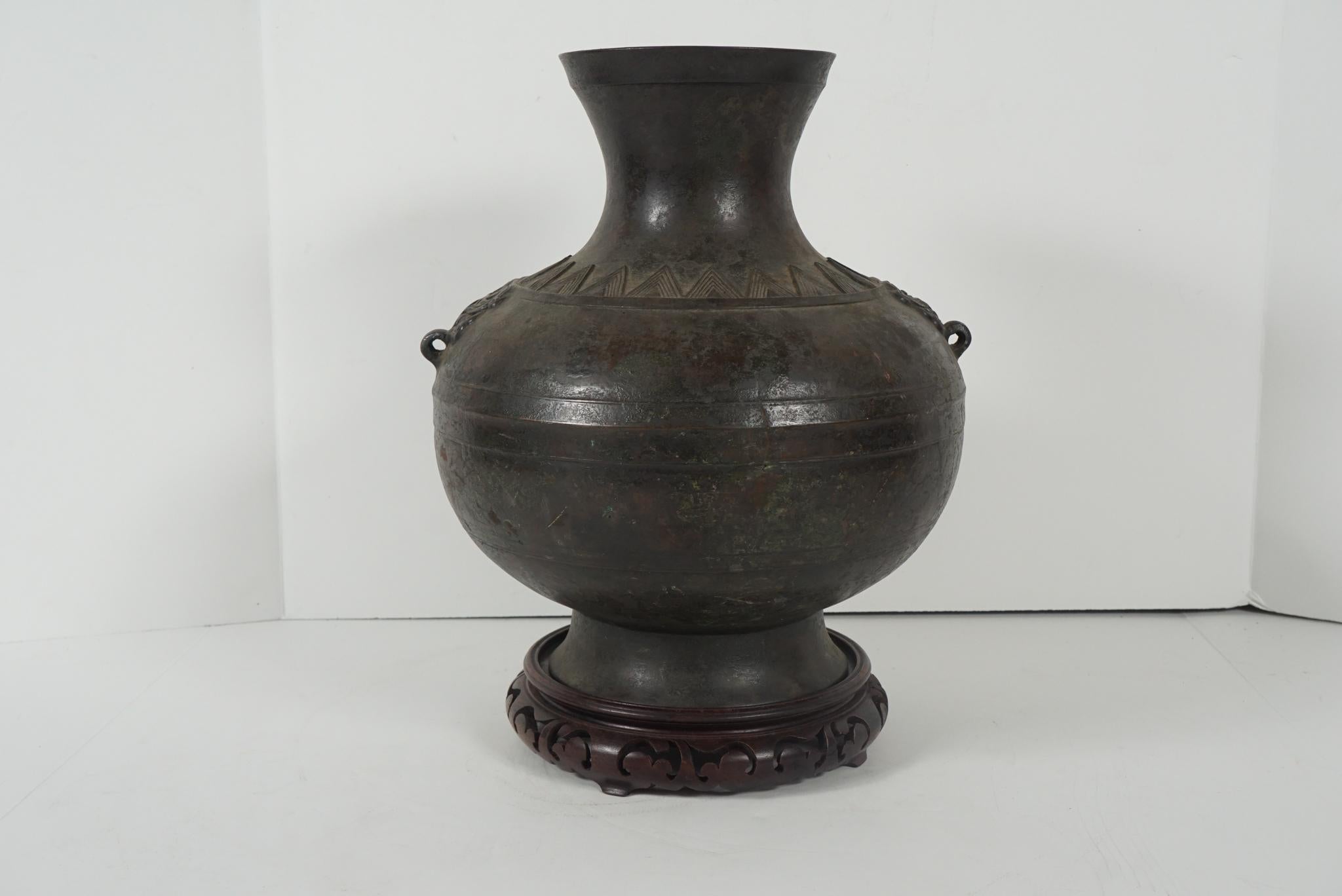 This fine old urn cast as an honorific nod to the ancient past of China was made circa 1600-1650. The shape or Hue was a common and well-represented form in the Han dynasty in pottery and bronze. This urn shows thin casting to the walls with