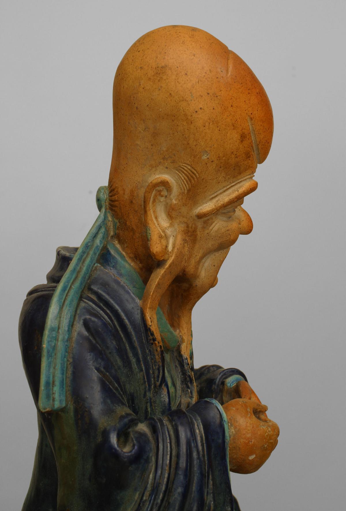 Asian Chinese (Ming Dynasty-Circa 1500) blue & green porcelain Shou Lau seated figure with oversize head (symbolism of longevity & luck) on a base supported with 4 figures.