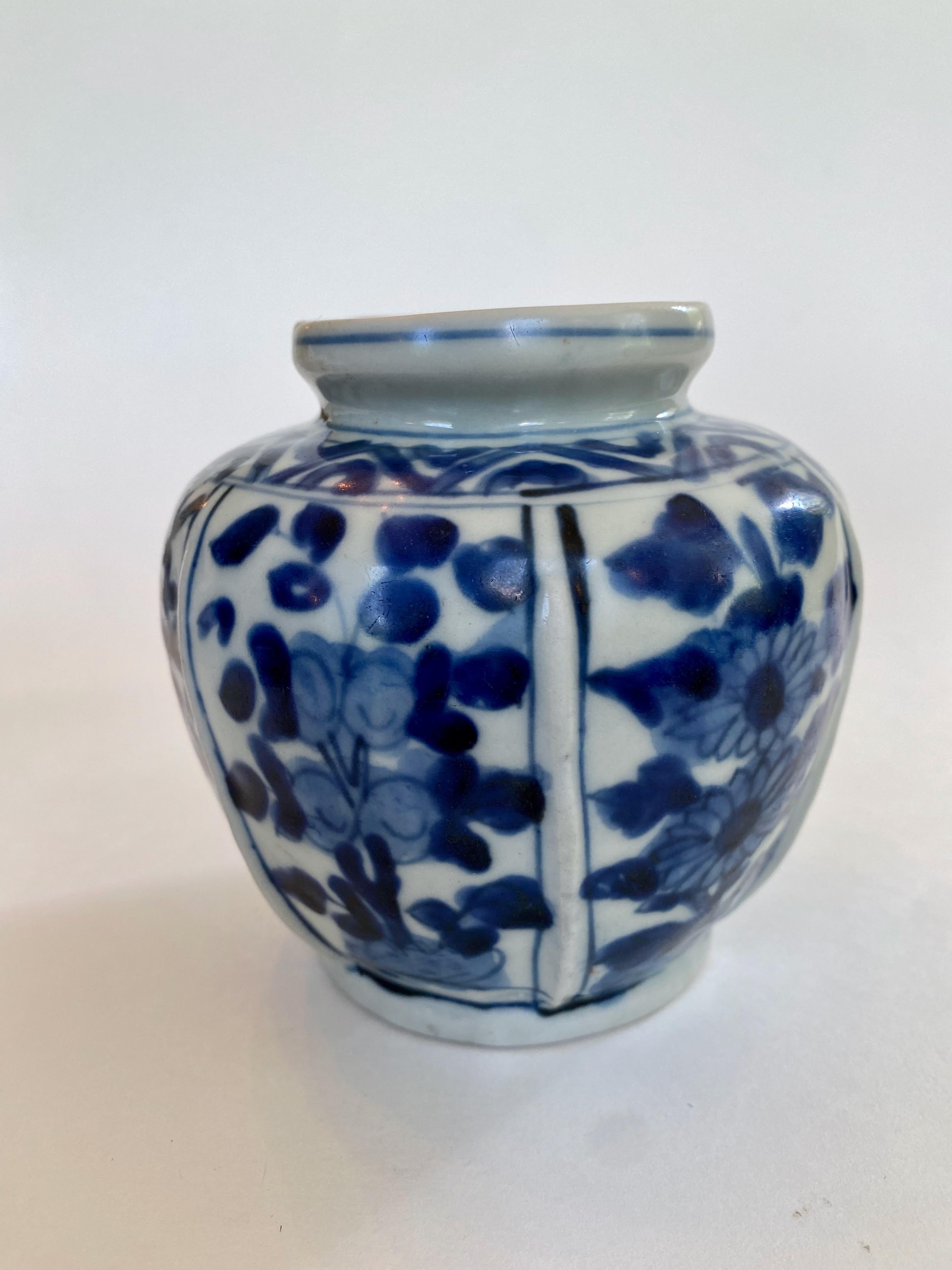 Ming Dynasty blue and white ribbed vase from the Wan Li period (1563-1620). The raised ridges on the body separate panels of boldly painted, stylized flowers, including sunflowers, in vibrant cobalt blue. The vase also has a geometric decorative