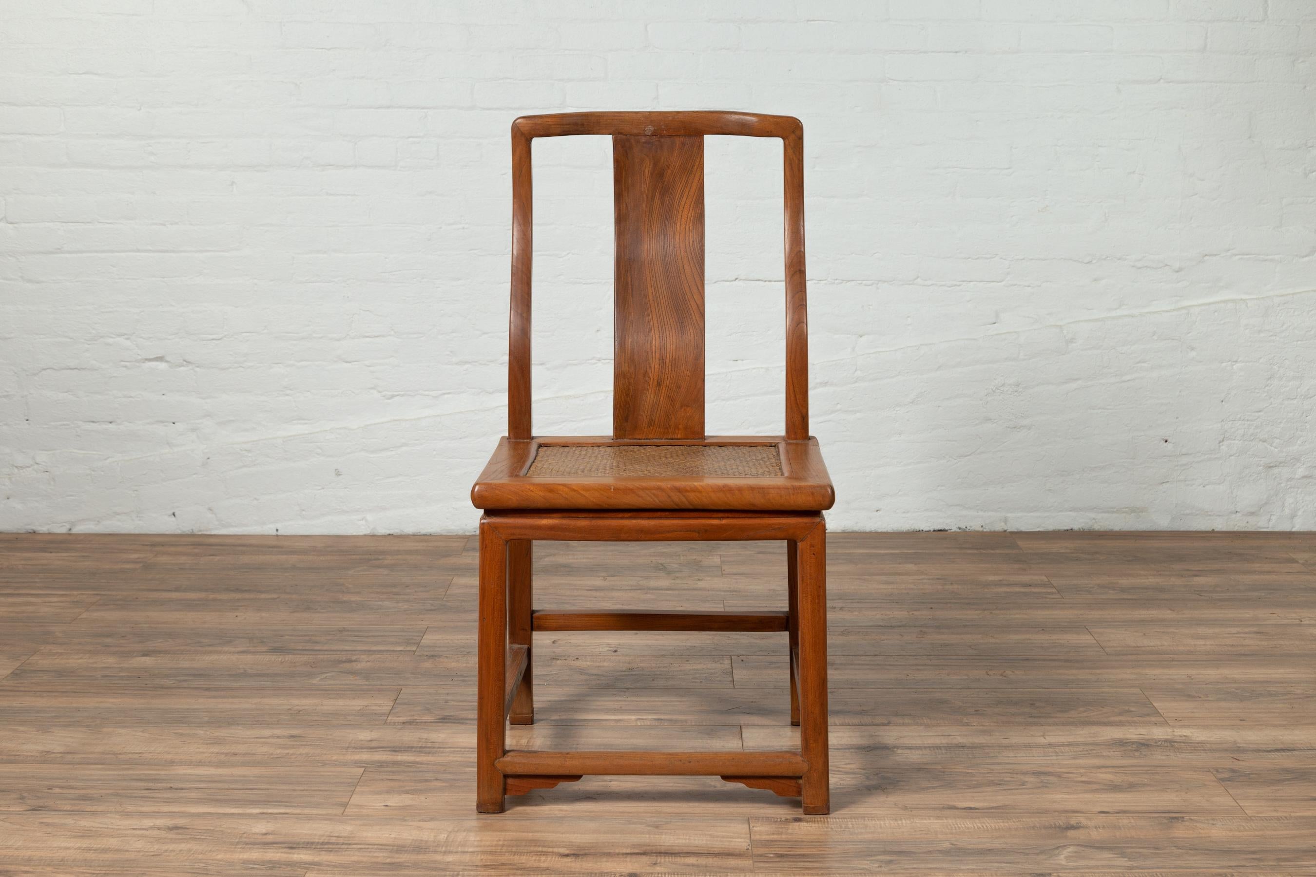 A single Chinese Ming dynasty style vintage wedding side chair from the mid-20th century, with woven rattan seat, curving back splat and natural wood patina. Born in China during the mid-century period, this elegant side chair features an open back