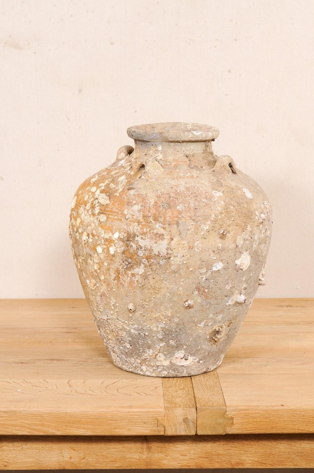 This centuries-old ceramic vessel from Thailand is an excellent specimen of a salvaged ceramic jar from a shipwreck during in the Ming gap period. This antique jar from Thailand, circa early to mid 16th century, stands just over 20 inches in height