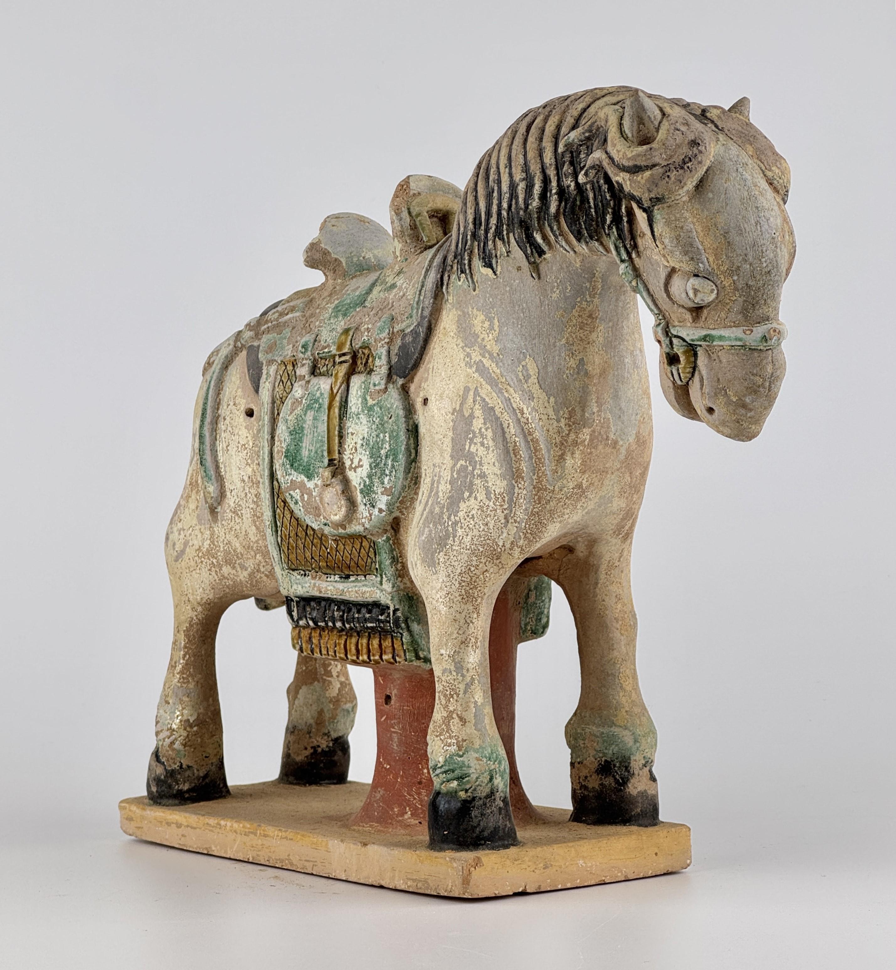 The figure stands on a rectangular base. The horse is depicted in a poised stance, with strong, muscular legs and a slightly bowed head. The mane is carefully sculpted with deep, flowing grooves, adding a dynamic texture to the piece. The head
