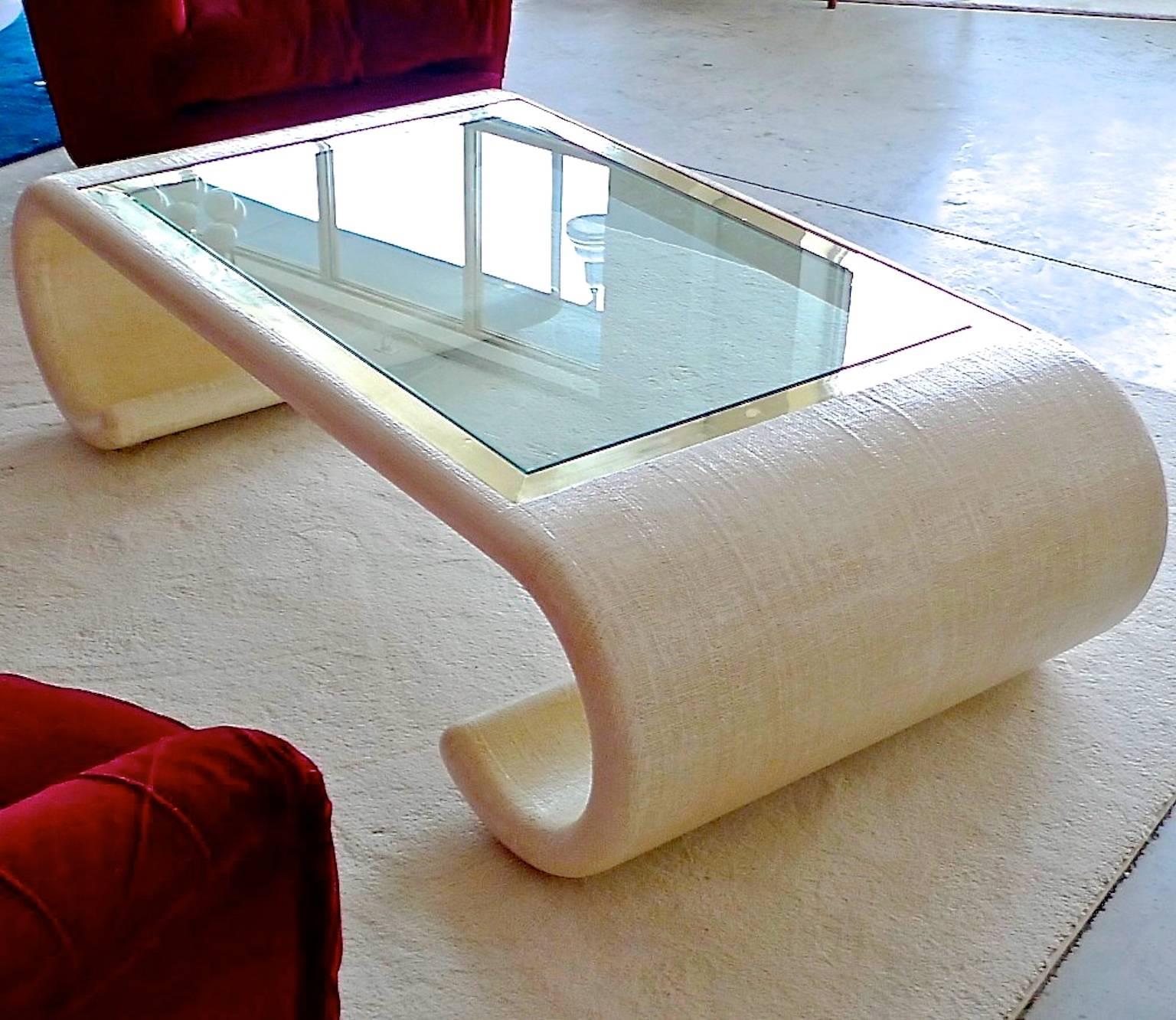 Large-scale vintage 1970s coffee table in Ming style scrolled form with inset rectangular glass top framed by squared edge polished brass, this table was designed by Ernest C. Masi and produced in Colombia by the French & English Furniture Company.