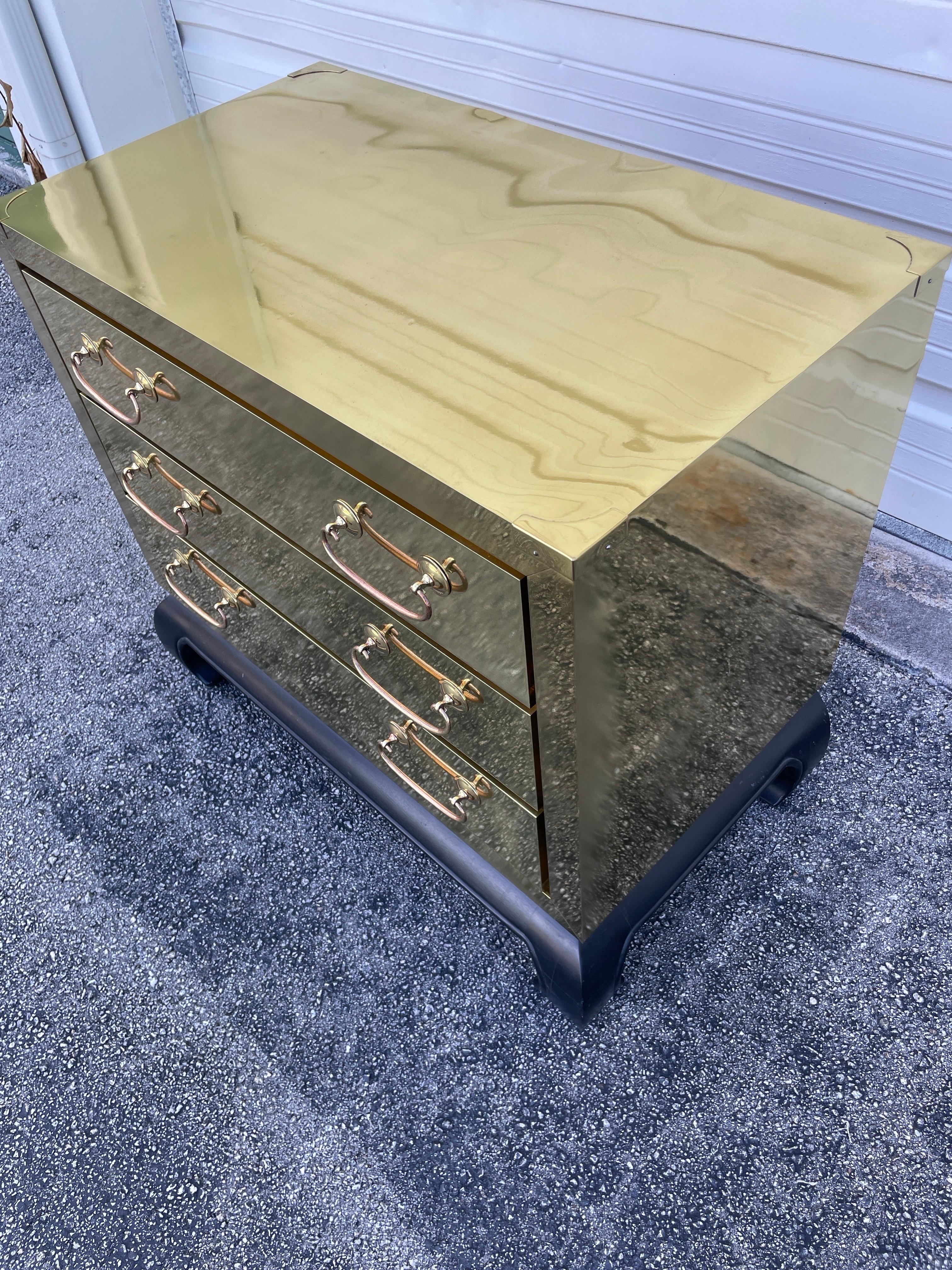 Vintage brass clad three drawer Mid-century designed chest with ming style black wood base. Made by Sarreid Ltd. Very well made with three functional drawers.