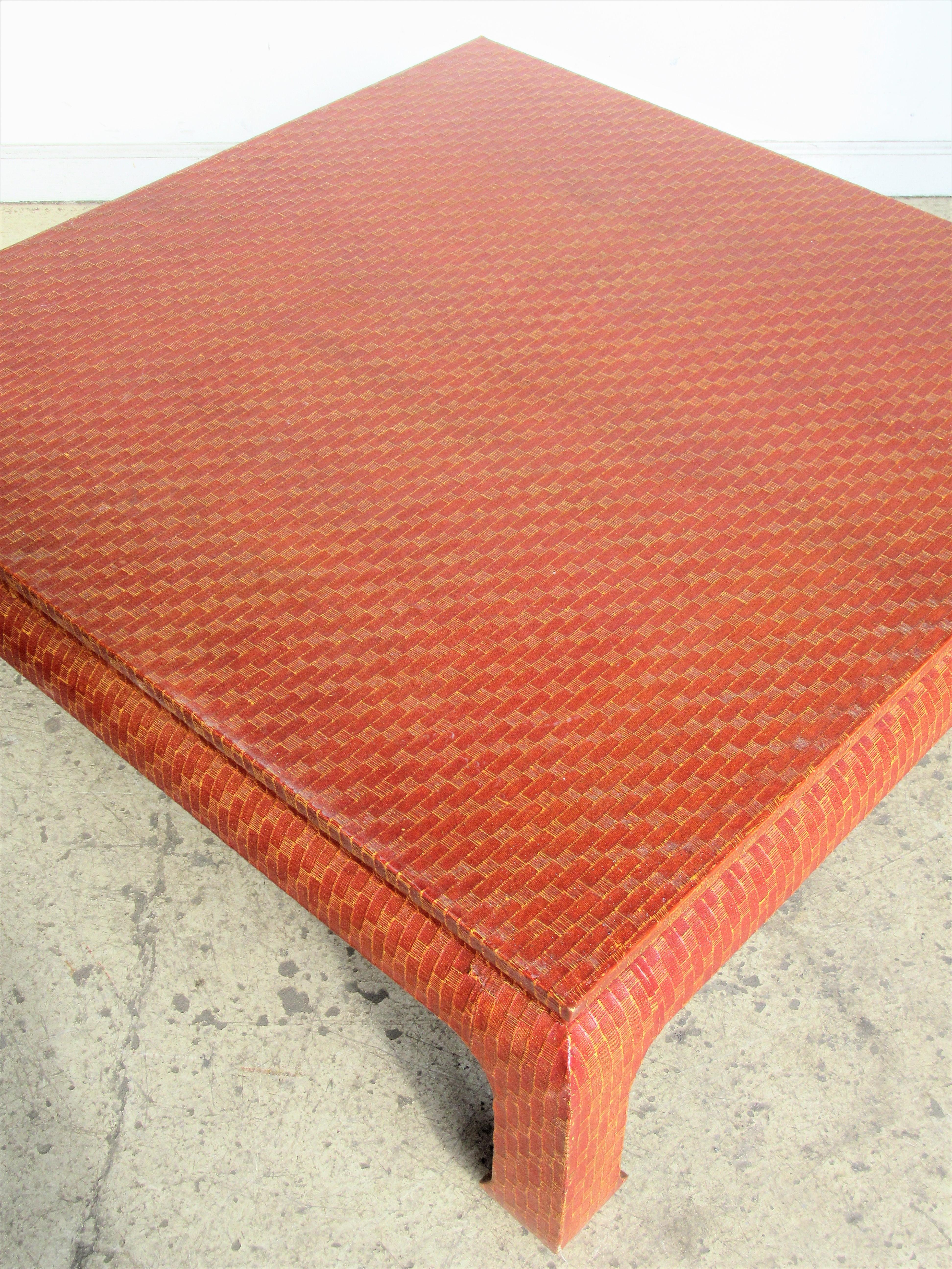 Texture patterned raffia wrapped Ming style coffee table by Baker Furniture in the most beautiful glowing custom burnt orange to sienna red tone finish. In the style of Karl Springer, circa 1970. This one is a showstopper. Look at all pictures and