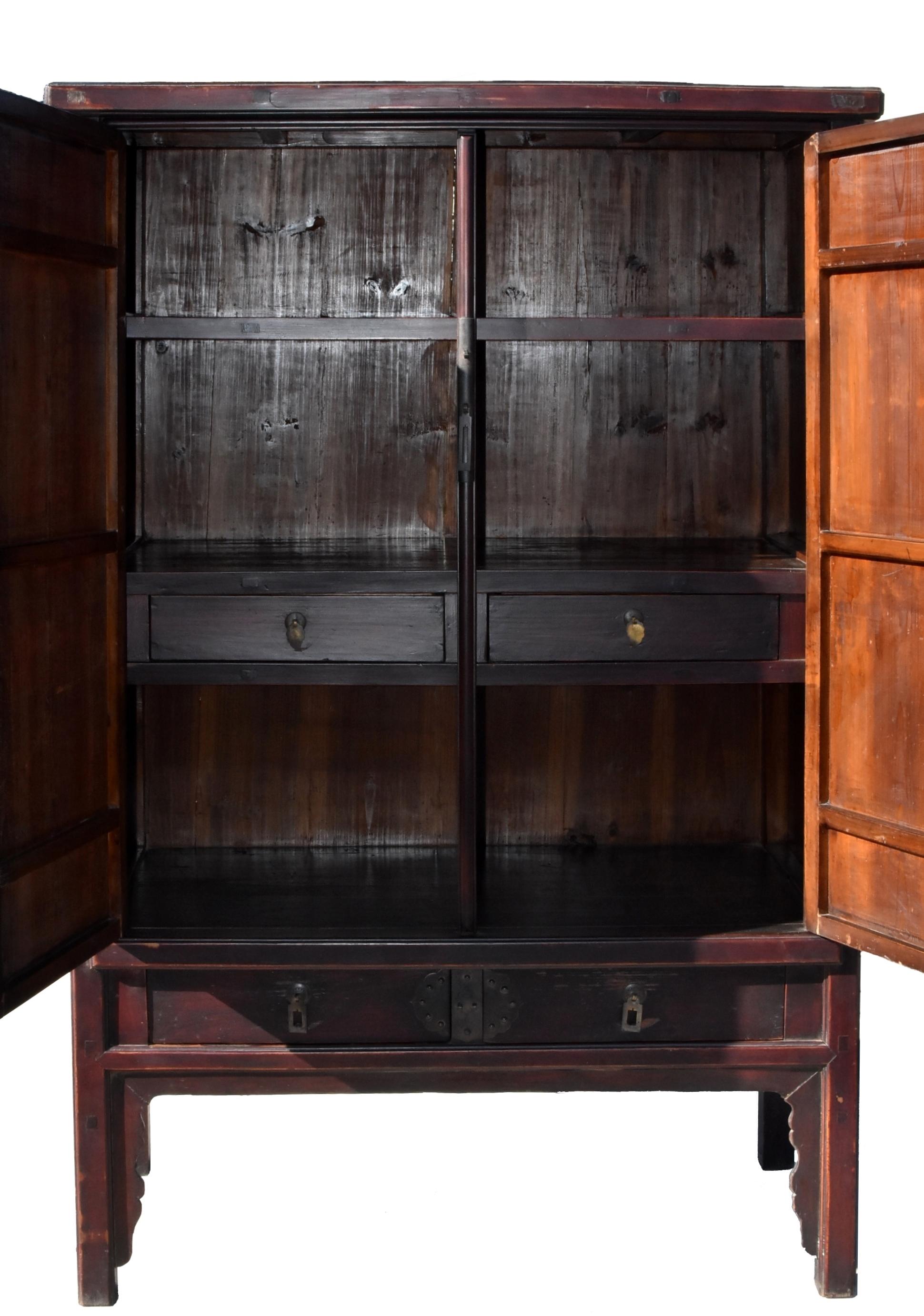 A beautiful, Ming dynasty style scholar's cabinet. The doors and side panels are all solid single boards set with mitered, tenon and mortise construction. Two exterior and interior drawers and a removable shelf above an apron and curved spandrels.