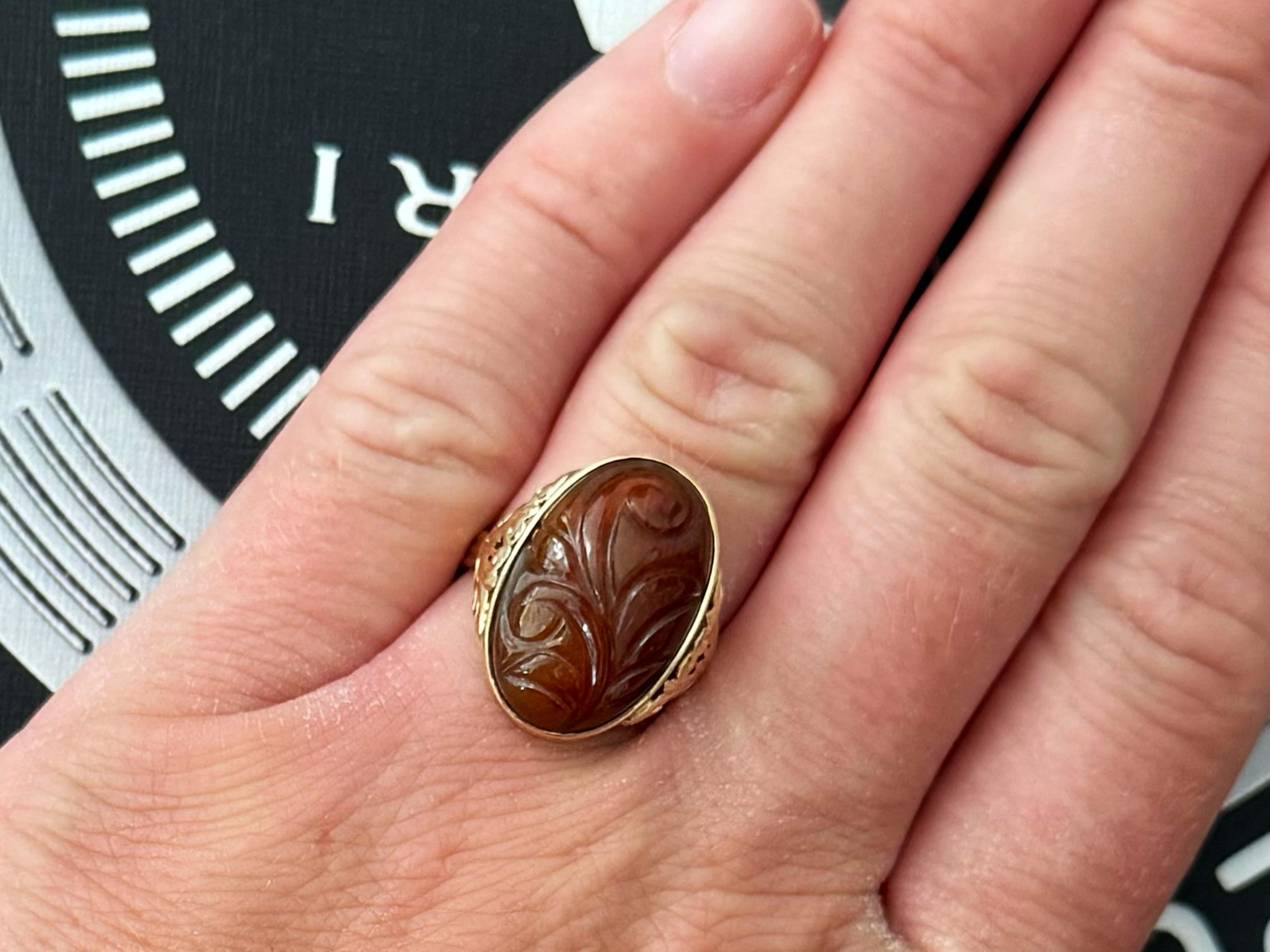 Ring Specifications:

Designer: Ming's Hawaii

Metal: 14k Yellow Gold

Jade: Red Brown Jade

Jade Measurements: 20 mm x 13 mm x 6 mm
​
​Jade CAarat Weight: ~14 carats

Total Weight: 6.1 Grams

Ring Size: 6.5 (resizable)

Stamped: 