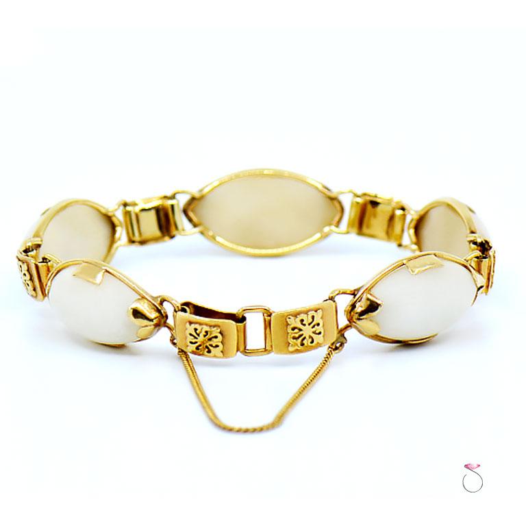 Beautiful vintage Ming's Hawaii white jade sectional bracelet in 14k yellow gold. The Bracelet features 5 cabochon navette shape white jade pieces seperated by a square link with a raised hawaiian quilt design. This bracelet is hinged for