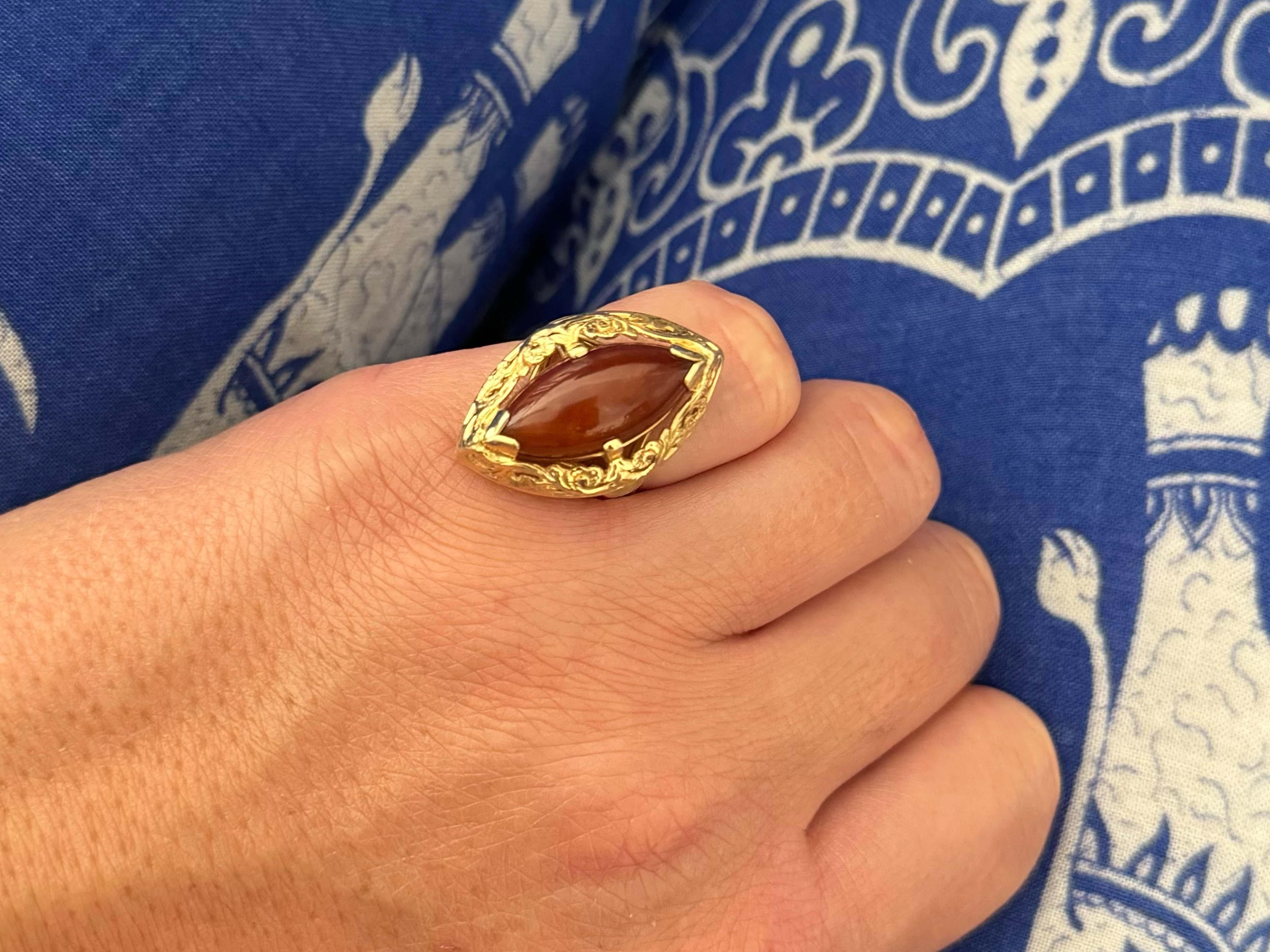 Ring Specifications:

Designer: Ming's

Metal: 14k Yellow Gold

Jade: Red Jade

Jade Measurements: 20 mm x 9 mm x 5 mm

Total Weight: 7.7 Grams

Ring Size: 6 (resizable)

Stamped: 