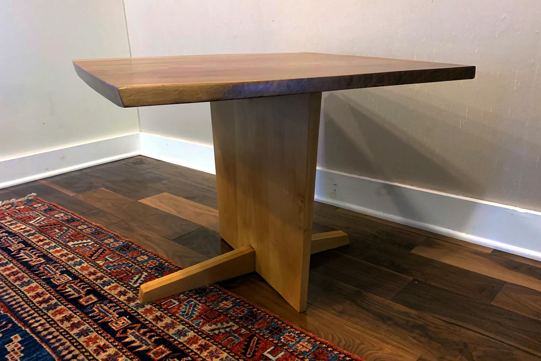A square pedestal table with Minguren I type support by George Nakashima circa 1968. Featuring an English walnut top with holly base, two free contoured edges and prominent wood grains. The table can be used as a coffee or side table but also makes