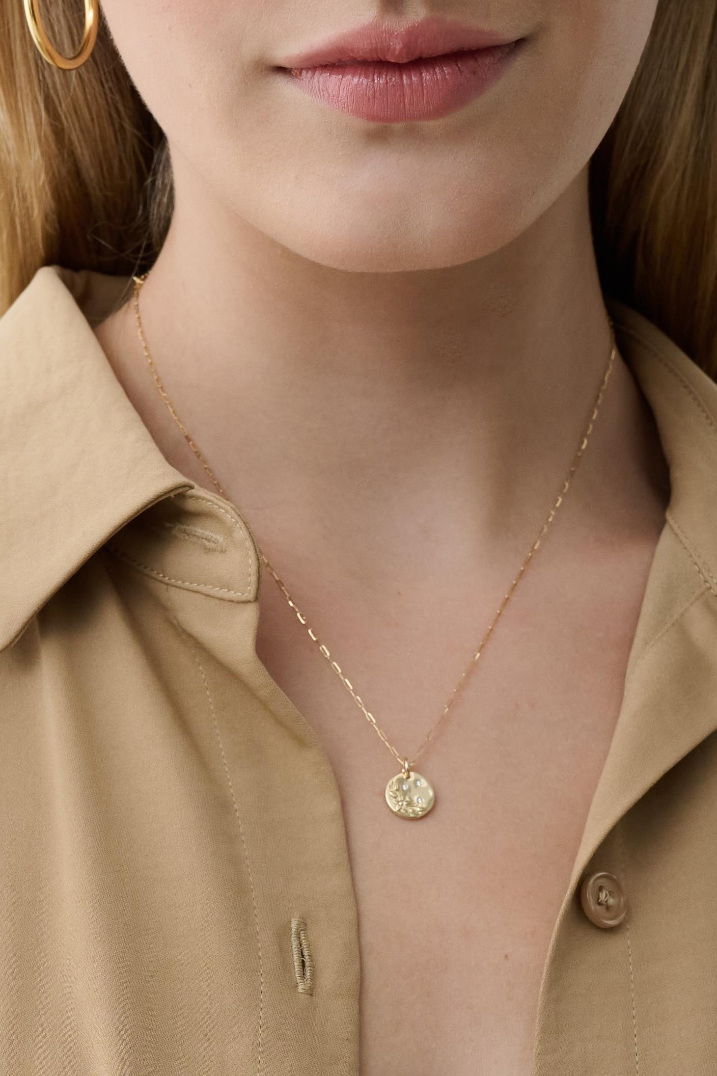 This delicate 14K gold necklace features a mini round flower medallion, surrounded by sparkling diamonds. Light and beautiful, it's the perfect accent for any outfit.  Pendant Slides off chain so you can wear the medallion on a different chain or