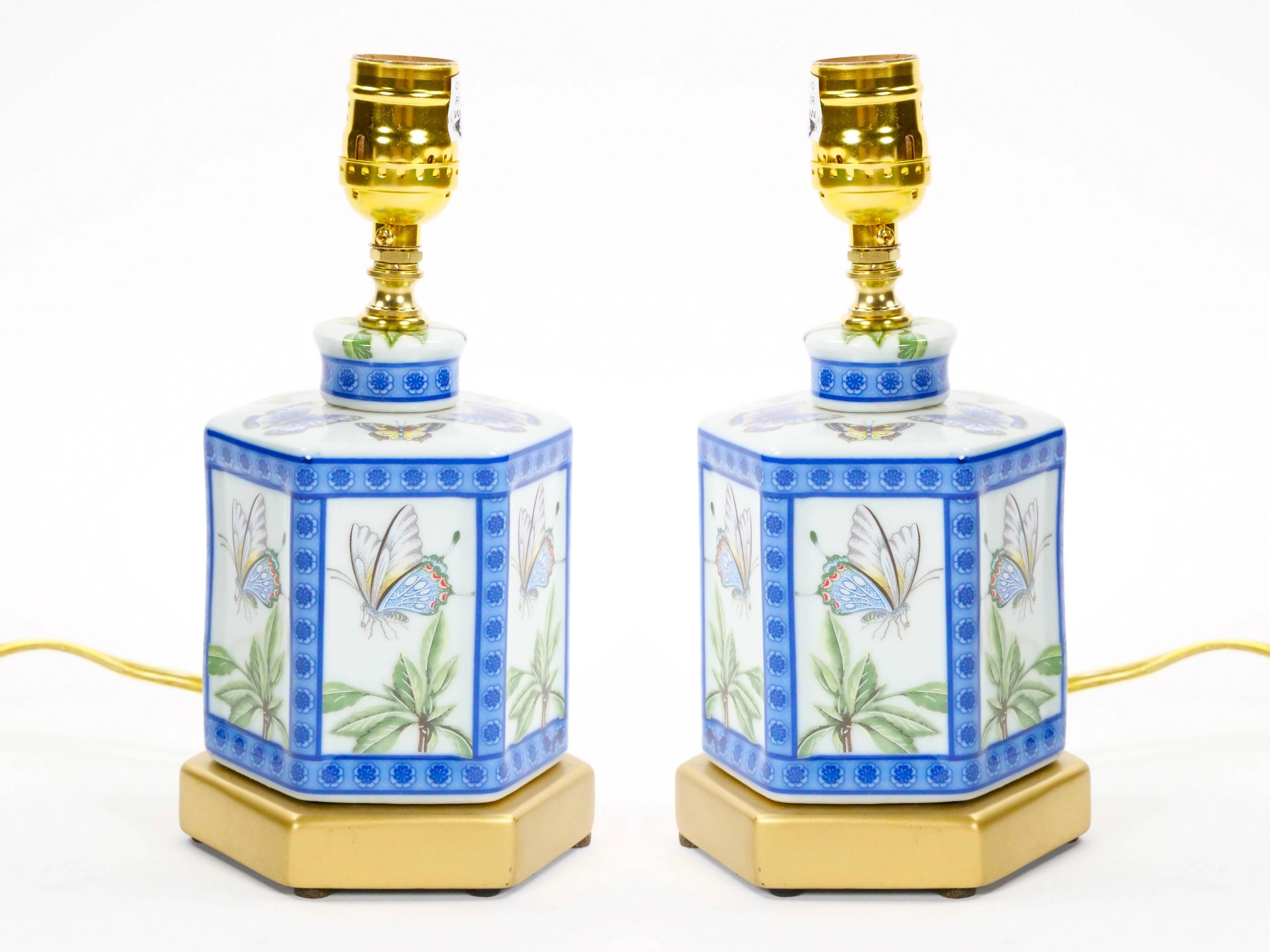 Cette exquise mini-lampe de table en porcelaine du XXe siècle témoigne d'un art délicat et d'une élégance intemporelle. Sur un fond blanc immaculé, la lampe présente de magnifiques papillons peints à la main dans des tons bleus et verts, entourés de