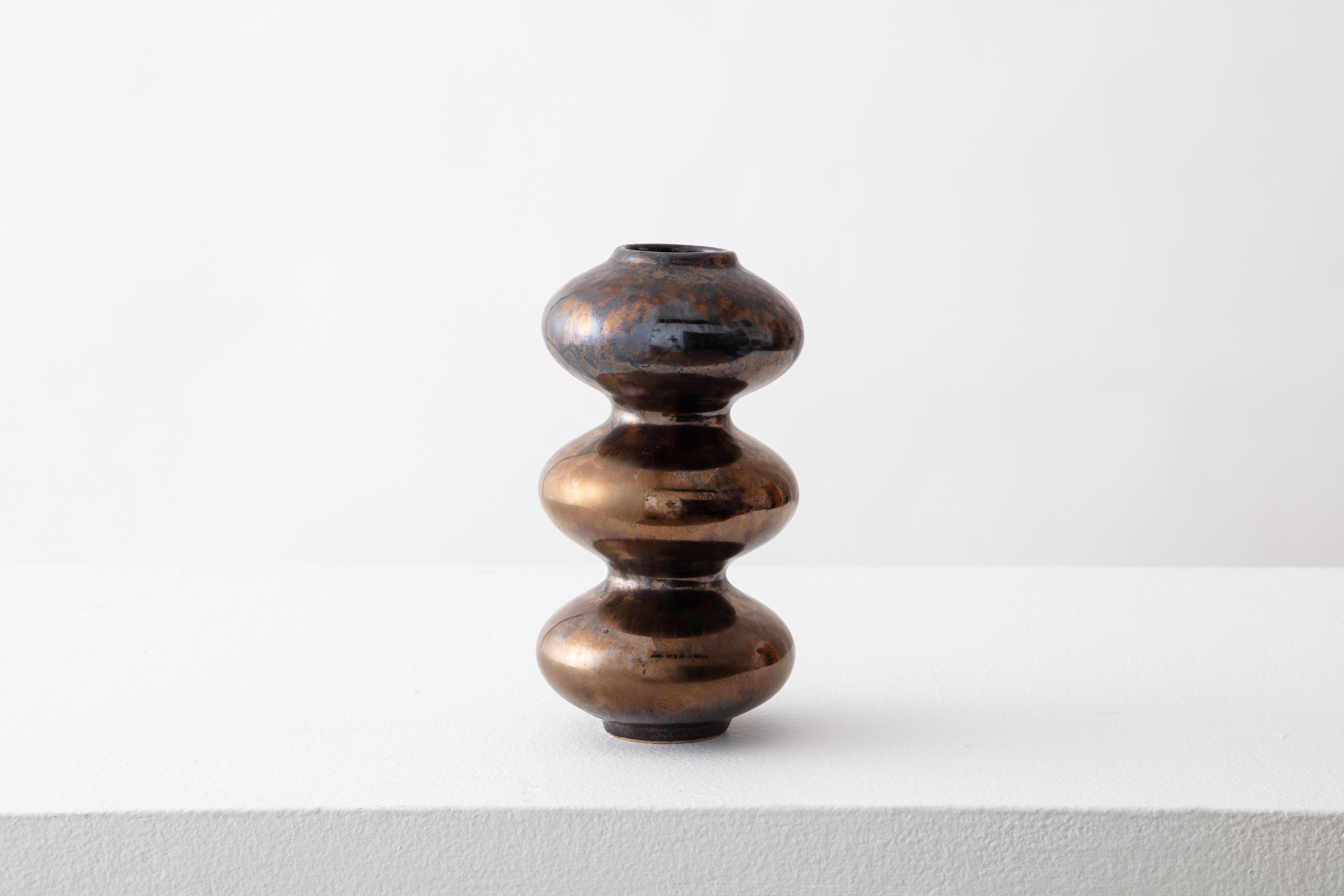 Mini Bronze Wave Form Vase by Forma Rosa Studio
Dimensions: D 8.9 x W 8.9 x H 17.8 cm.
Materials: Ceramic.

Available in Crystal Cream, Mint Blue, Bronze, Green, and Oxblood colors.

Our Wave Form Vase Mini is our classic timeless design, developed