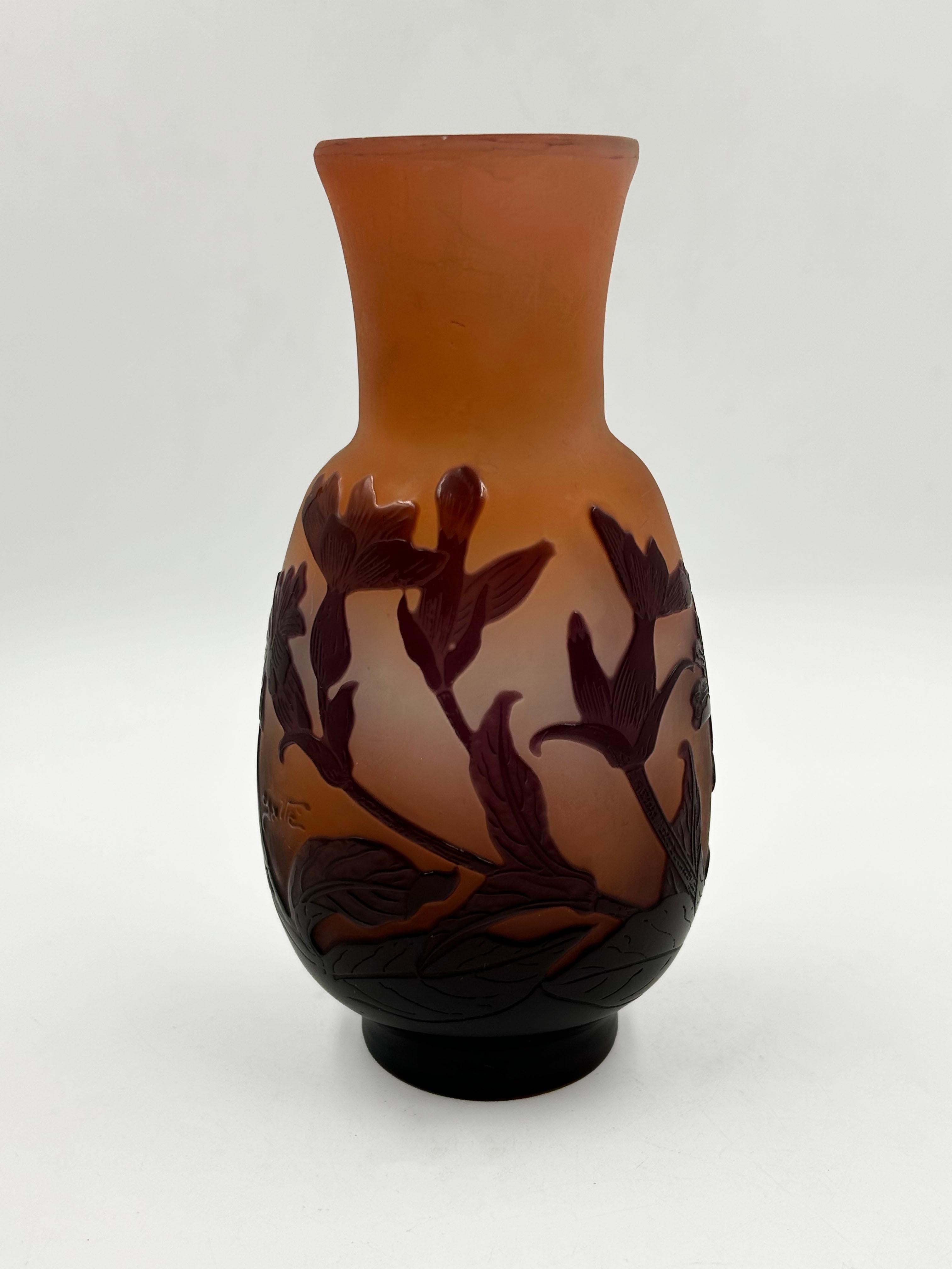 Mini Cameo Vase by Emile Galle
This is a multi-layered glass vase, characteristic of the Art Nouveau style, made using the acid-etched cameo technique. It features an ovoid body with a flared neck and is decorated with a relief botanical design of