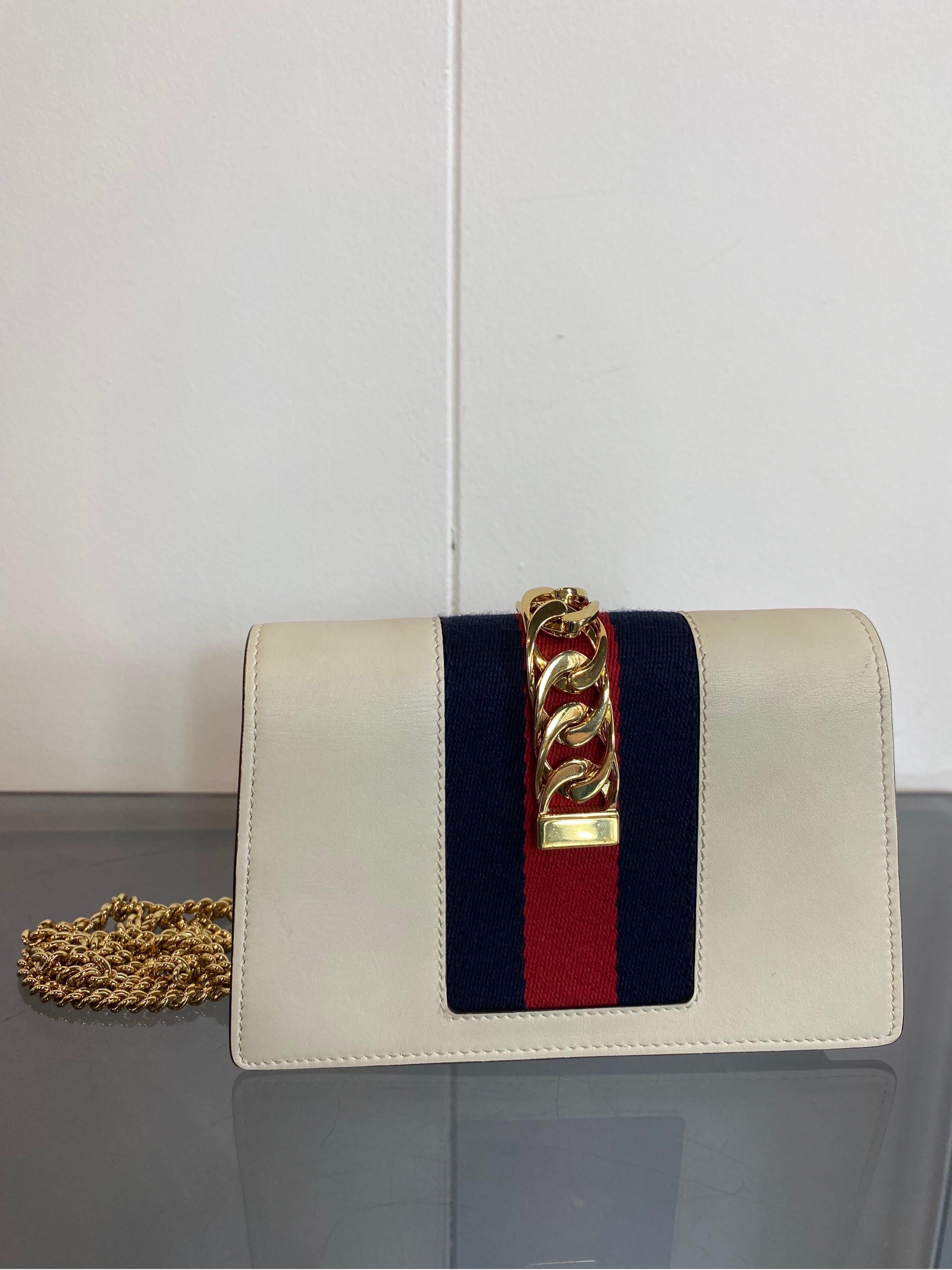 Sylvie Gucci bag
Mini white chain. Leather. 
With gold hardware and removable chain.
Clutch worn both by hand and crossbody.
Suede internal part.
Automatic closure with magnet.
Inside is a key ring with hook still covered in protective