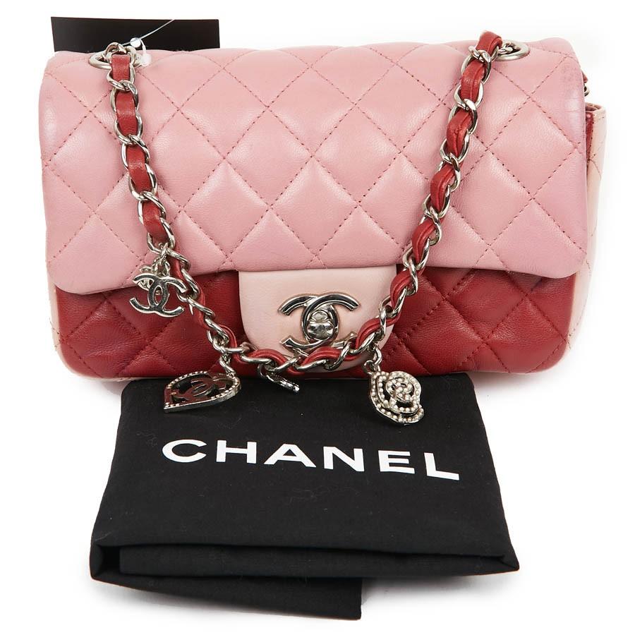 Mini Timeless CHANEL Tasche aus dreifarbigem:: puderrosa:: rosa und rotem Lammfell. Der Schmuck ist aus silbernem Metall. 
Der Schulterriemen ist mit rotem Leder und kleinen hängenden Anhängern verwoben:: einige Perlen fehlen (können hinzugefügt