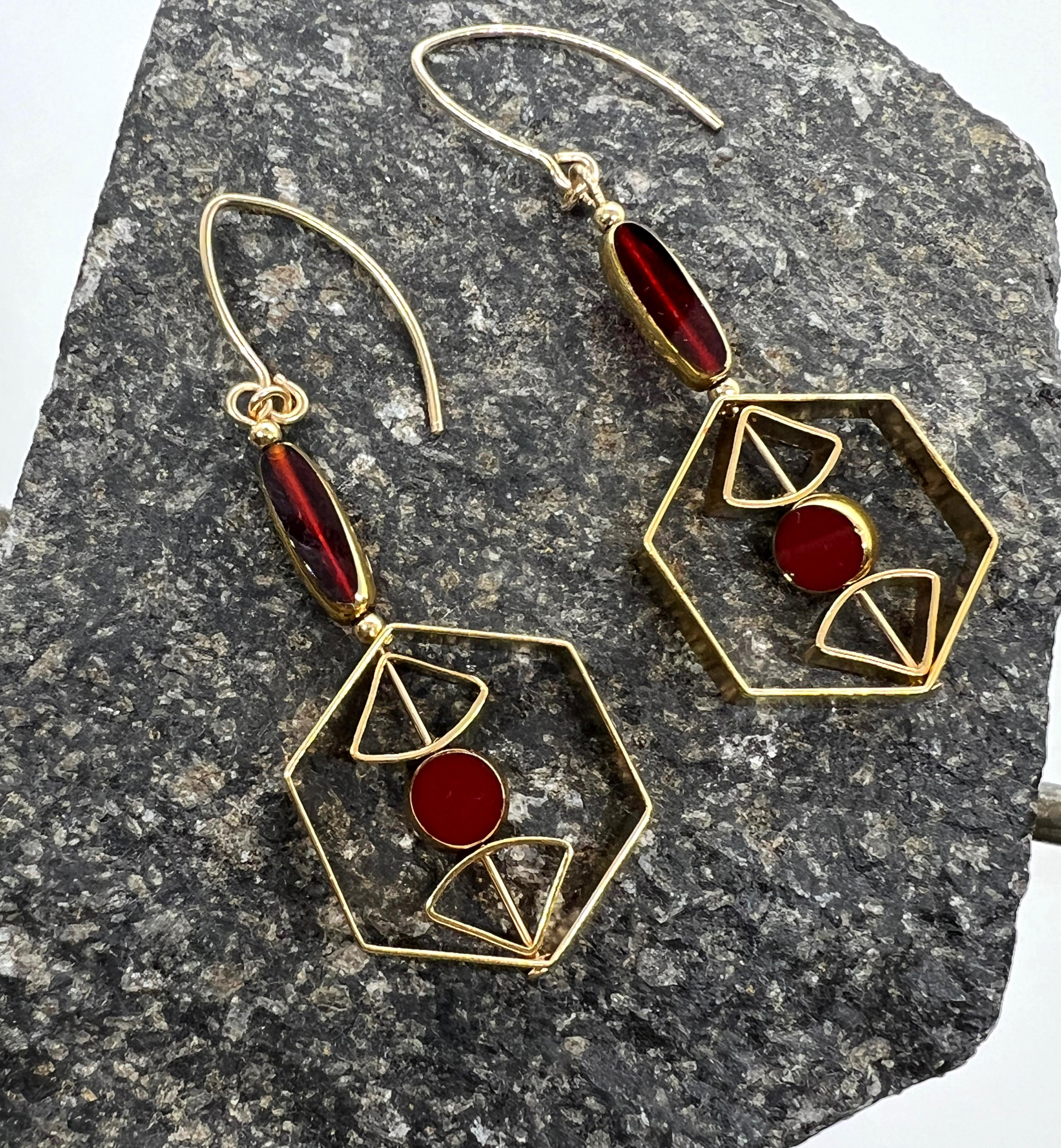 The earrings are light weight and are made to rotate and reposition with movement.
The earrings consist of a red burgundy mini circle and mini oblong shaped beads. They are new old stock vintage German glass beads that are framed with gold. The