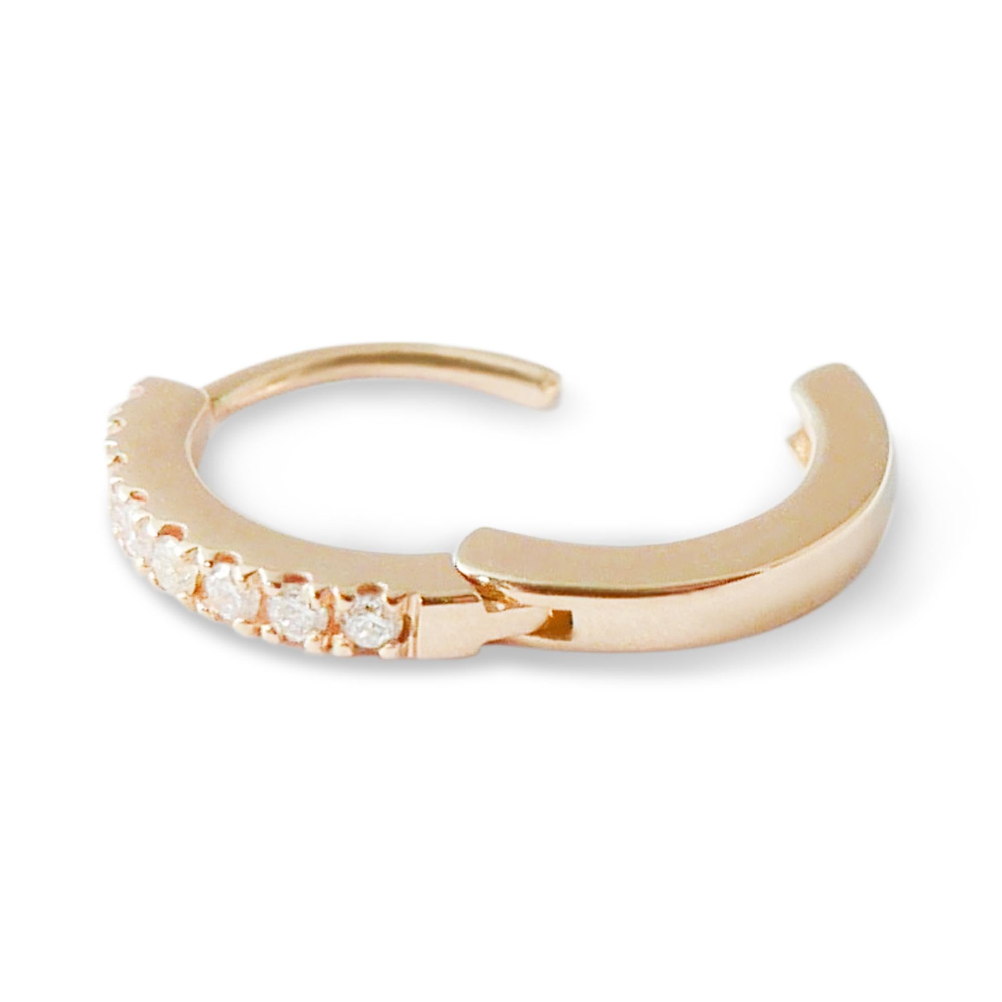 This pair of delicate huggie hoop earrings is crafted in 18-karat rose gold and set with 0.08 carats of white pave diamonds.  The earrings feature a classic 18-karat yellow gold pave setting and a click post fastening for a secure and close fit. 