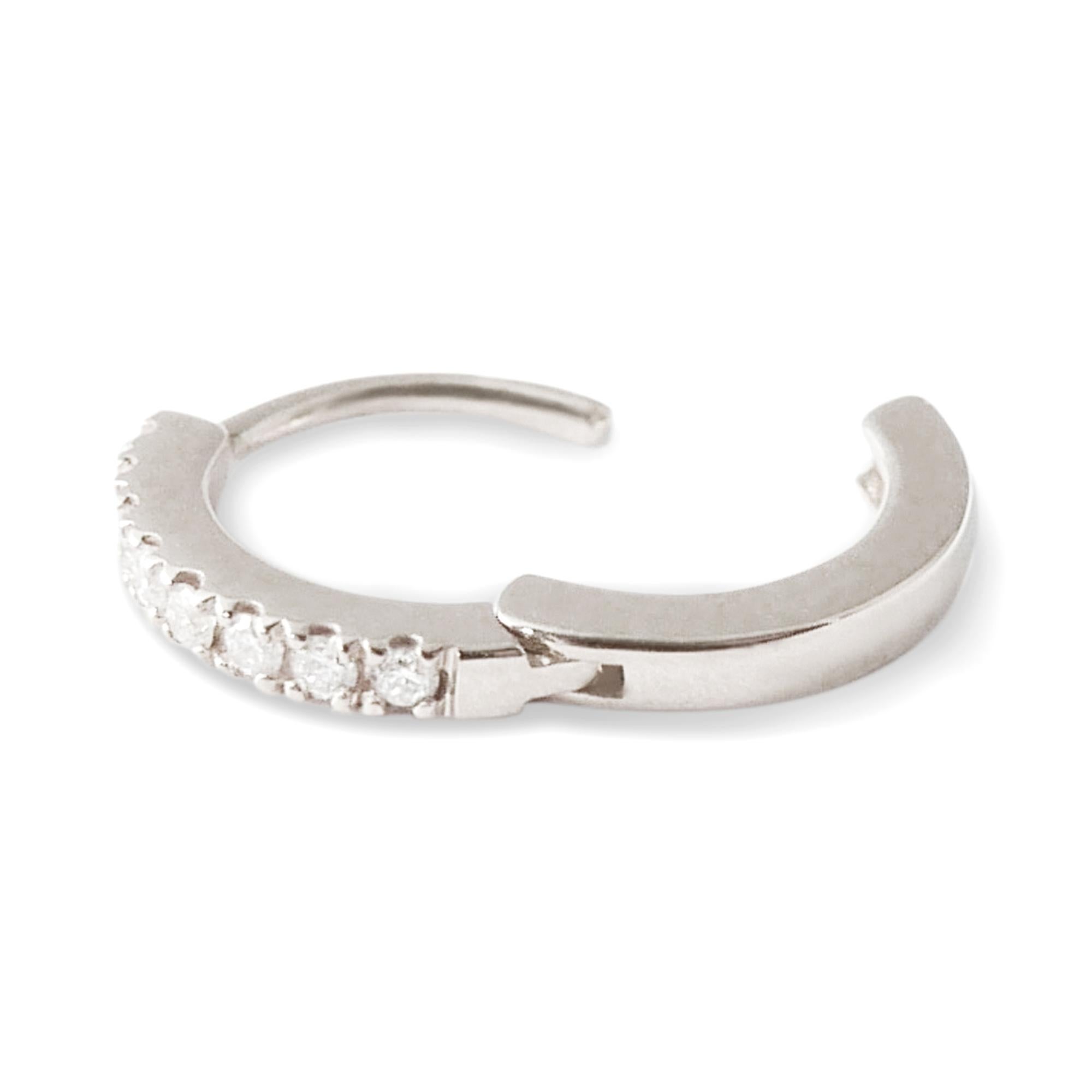This pair of delicate huggie hoop earrings is crafted in 18-karat white gold and set with 0.08 carats of white pave diamonds.  The earrings feature a classic 18-karat white gold pave setting and a click post fastening for a secure and close fit. 
