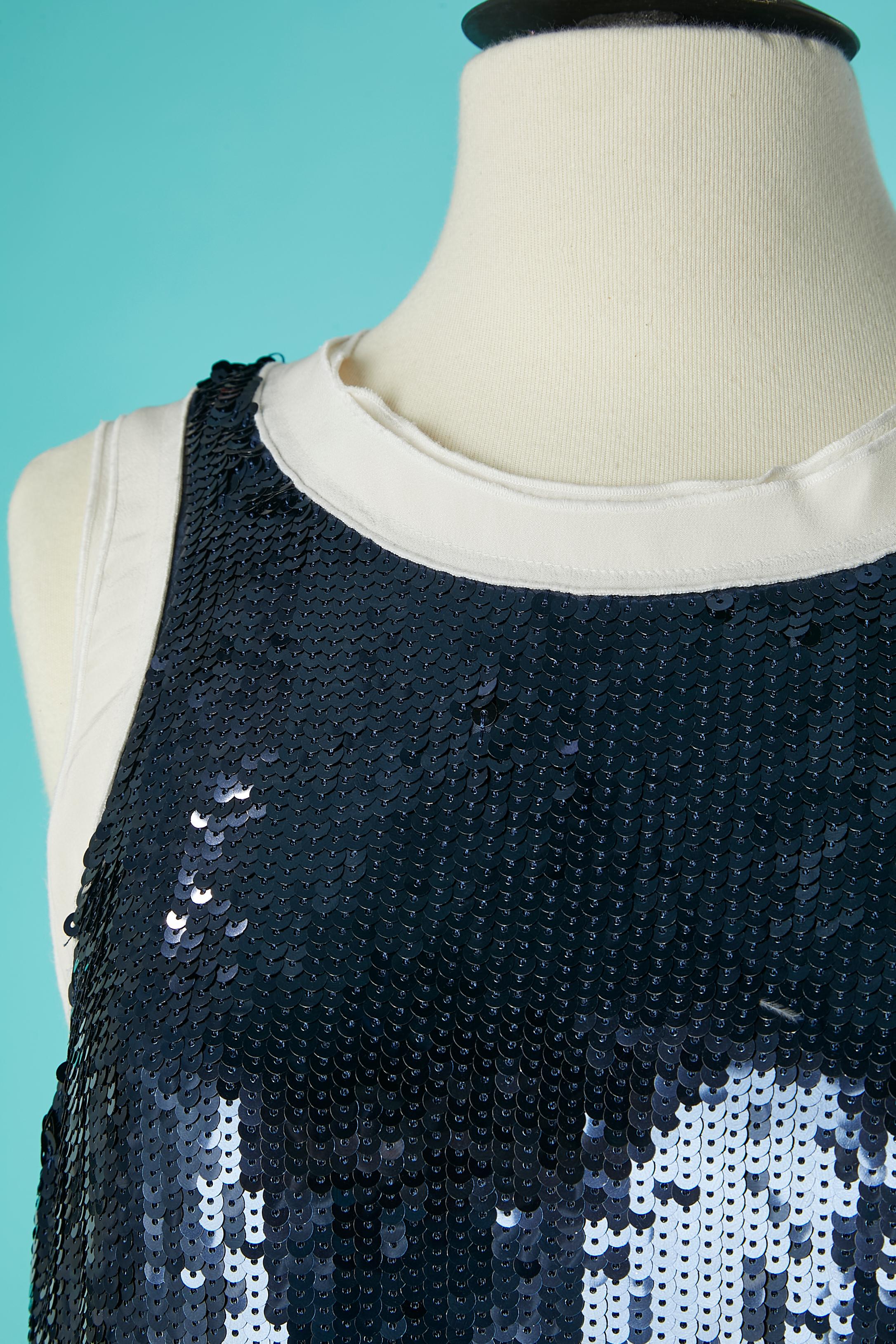 Mini robe en paillettes bleues avec motif Anchor et bord inférieur plissé. Composée de 2 superpositions de couches (celle du dessus en paillettes et celle du dessous en soie, terminée par une soie plissée).
Fermeture à bouton-pression en haut au
