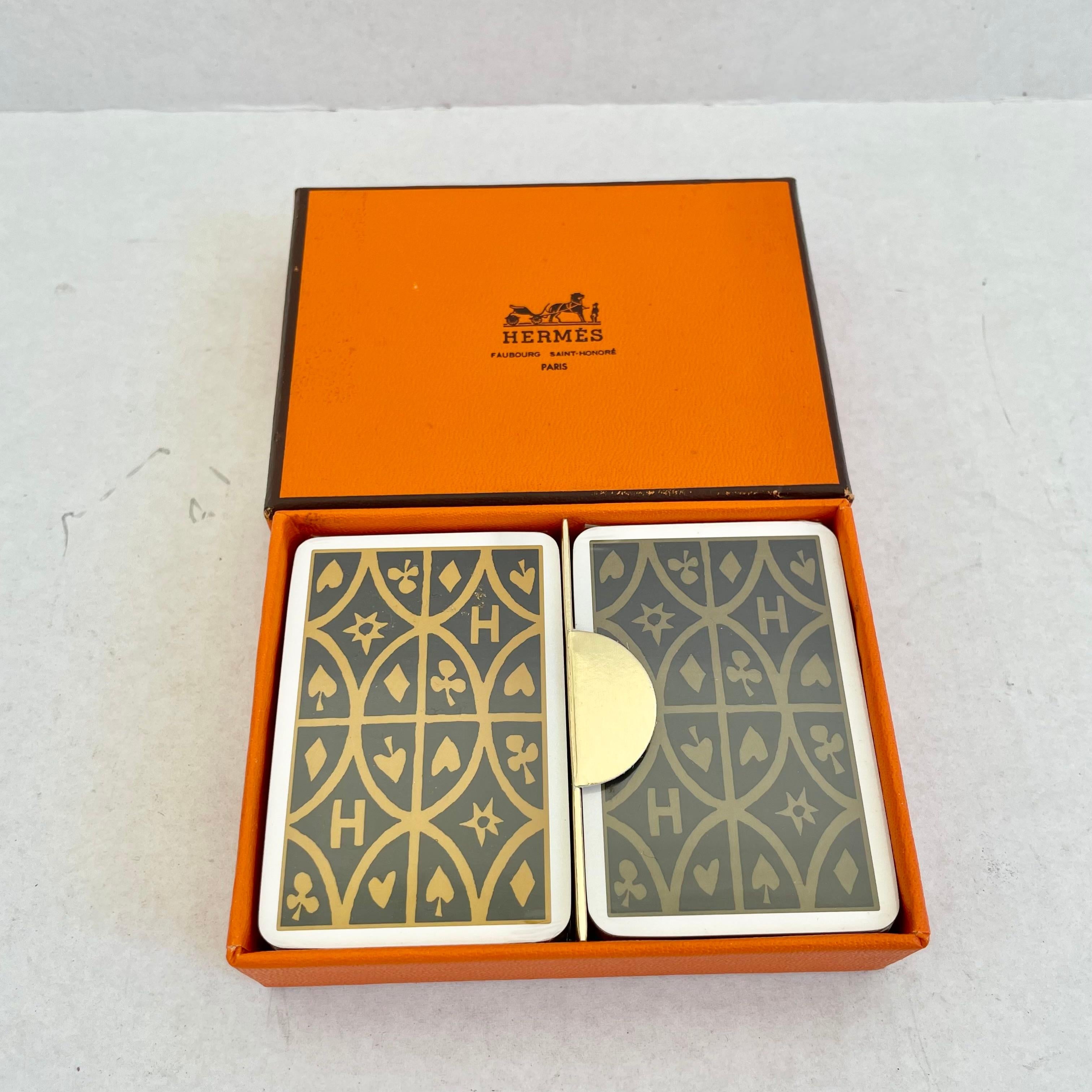 Hermès mini playing cards in the original box and original wrapping. Made in France. Both sets are sealed and unused. Gold gilded edges on both decks. One brown deck and one tan deck each with the Hermès 