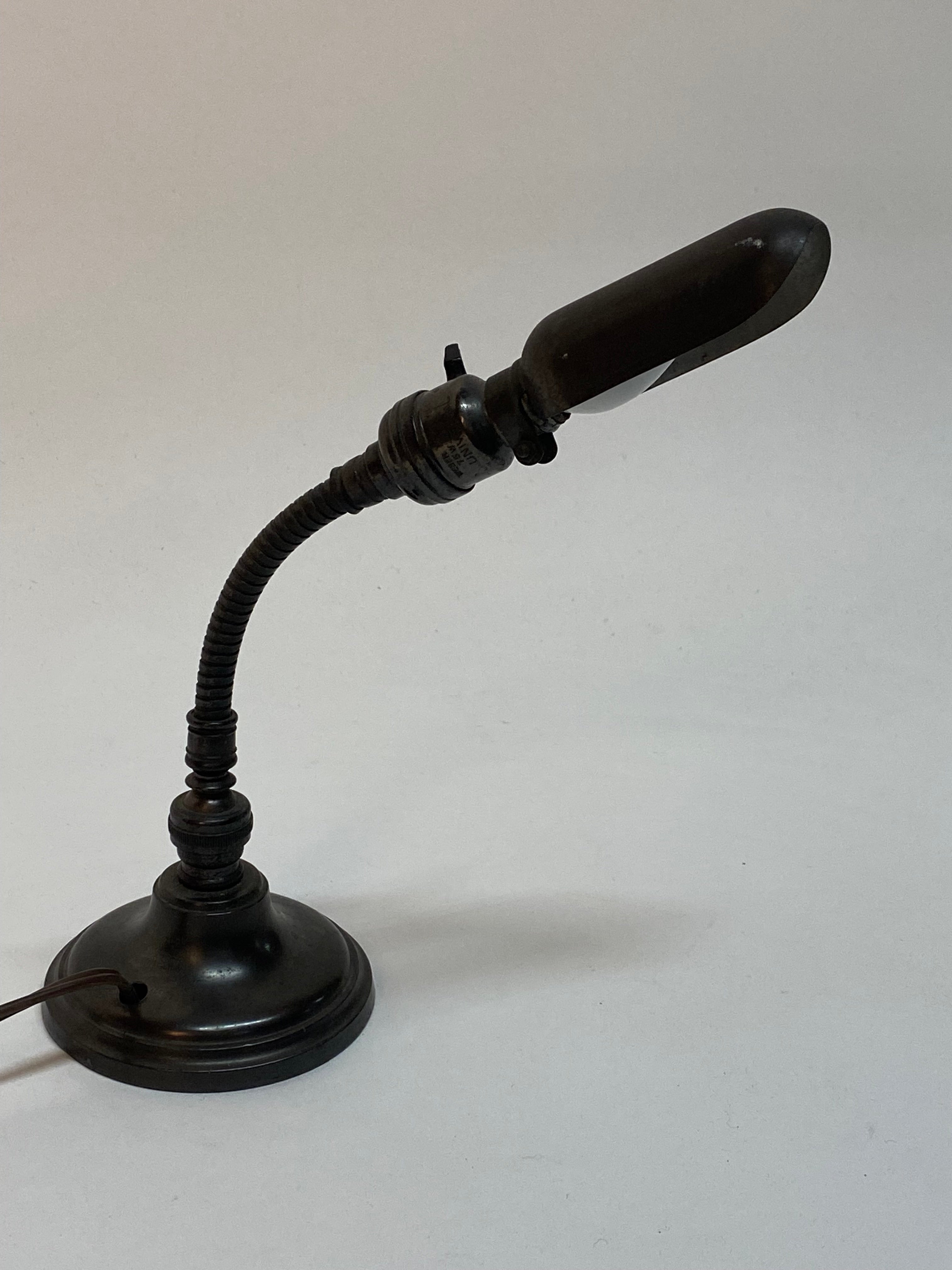 A great little lamp that will brightly light up the smallest of areas. Hubbell style mini work light with a round weighted base and adjustable gooseneck. Circa 1920-30. Good working condition with wear consistent with age and use. Minor cosmetic