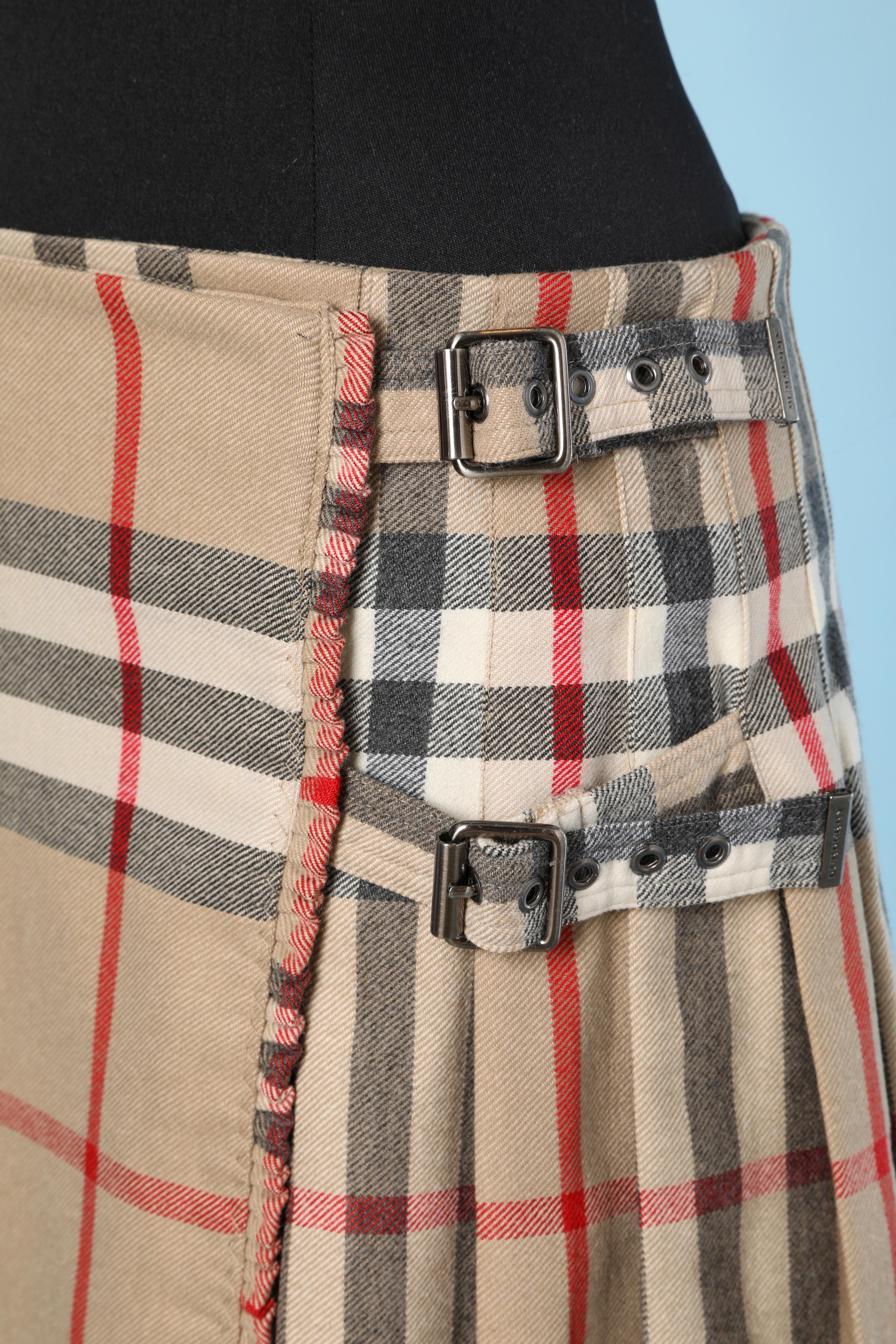 Mini kilt in wool tartan with tartan straps and metallic buckles. No lining 