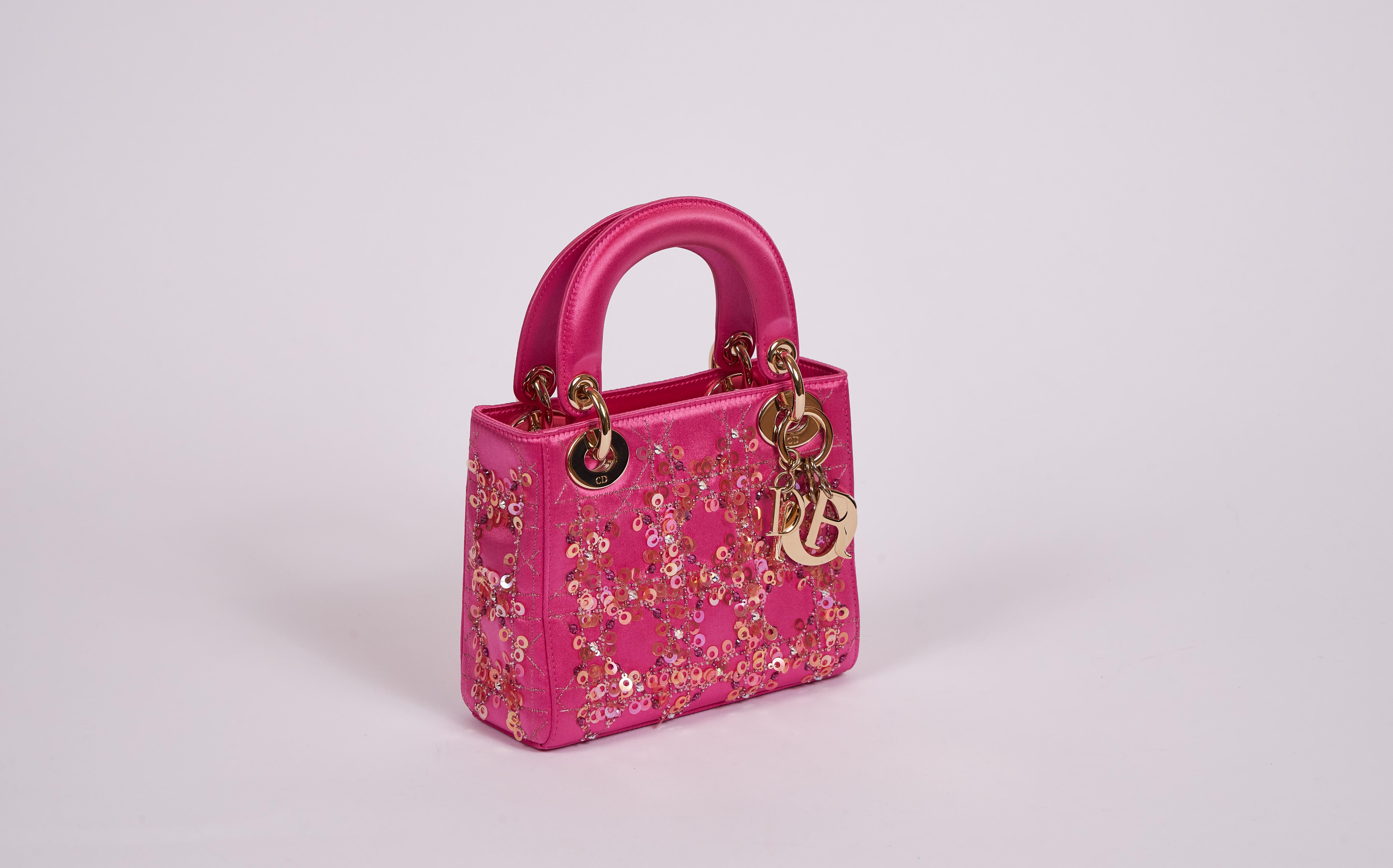 Mini lady Dior couture collection in hot pink satin silk and gold tone hardware. Pink and gold sequins applications. Gold tone dangling letters. Excellent condition with booklet and original dust cover.