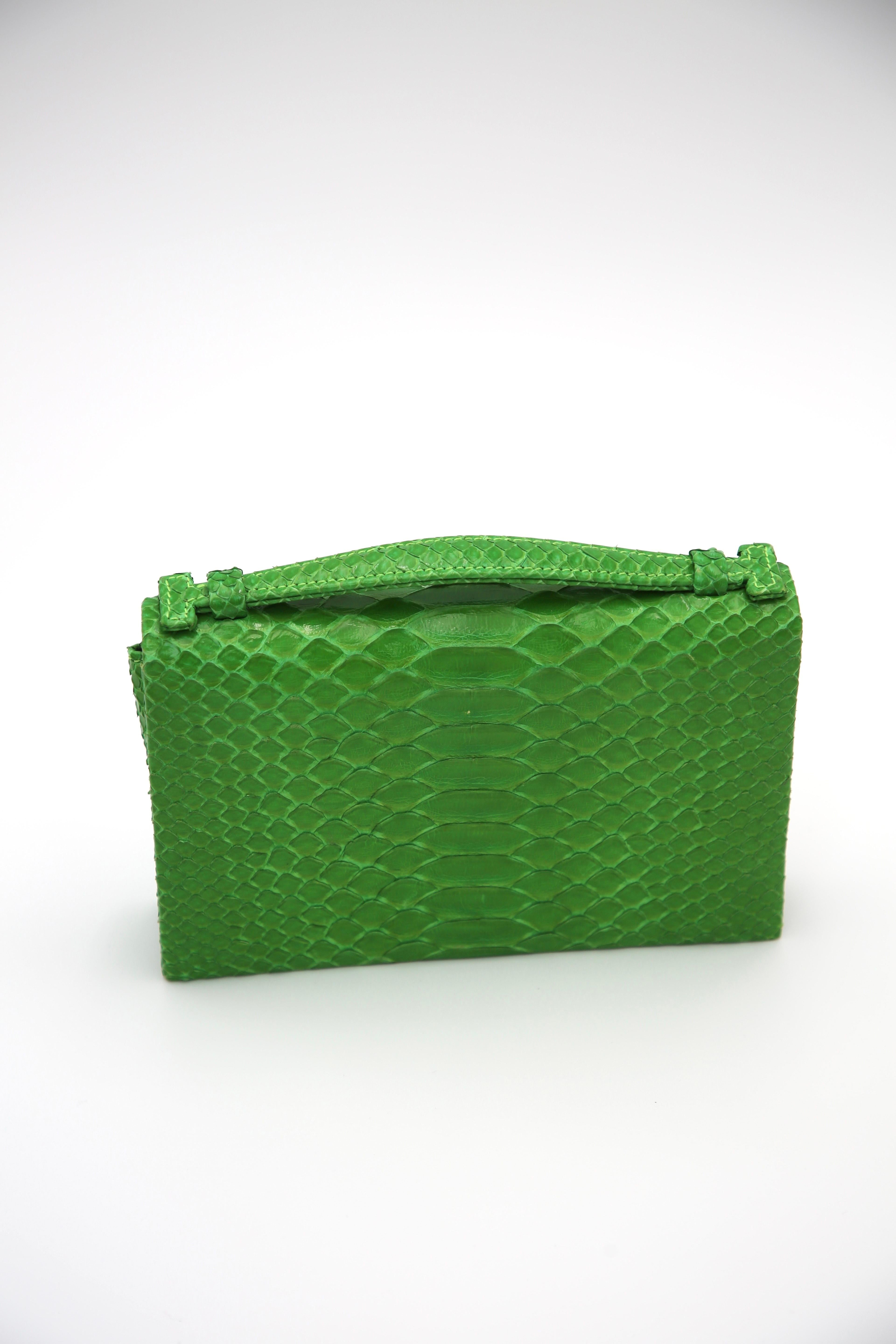 Die Mini Moderna Python von Susie Straubmueller ist eine kompakte, luxuriöse Handtasche, die den Inbegriff moderner Eleganz darstellt. Diese aus echtem Pythonleder gefertigte Tasche zeigt das Engagement des Designers für die Verwendung hochwertiger