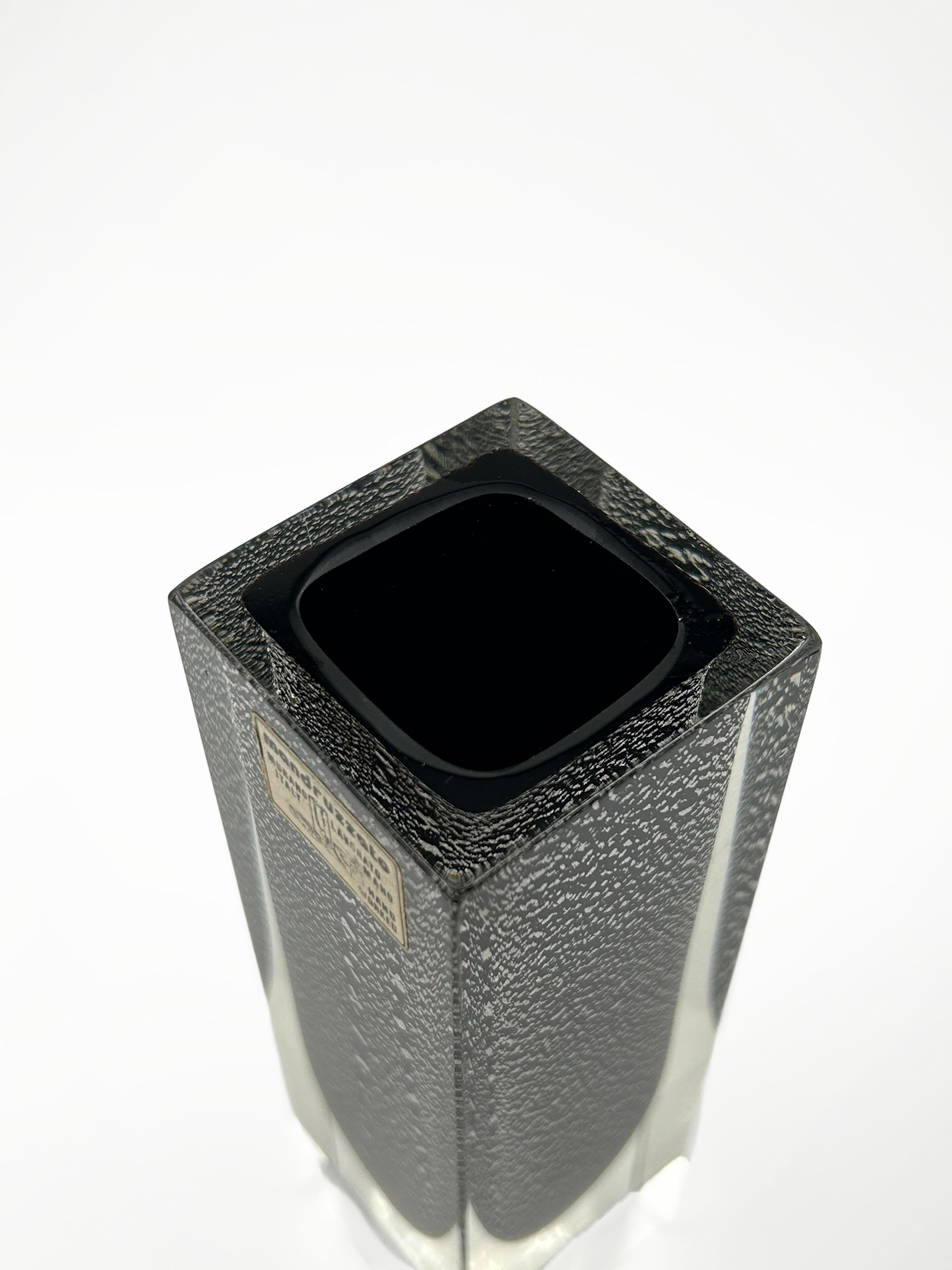 Mini Murano Mandruzzato Vase with 925 Silver Inclusions
This elegant, geometric mini vase was produced by the prestigious Mandruzzato workshop in Murano, renowned for its mastery of the sommerso technique and its faceted cuts with a sculptural