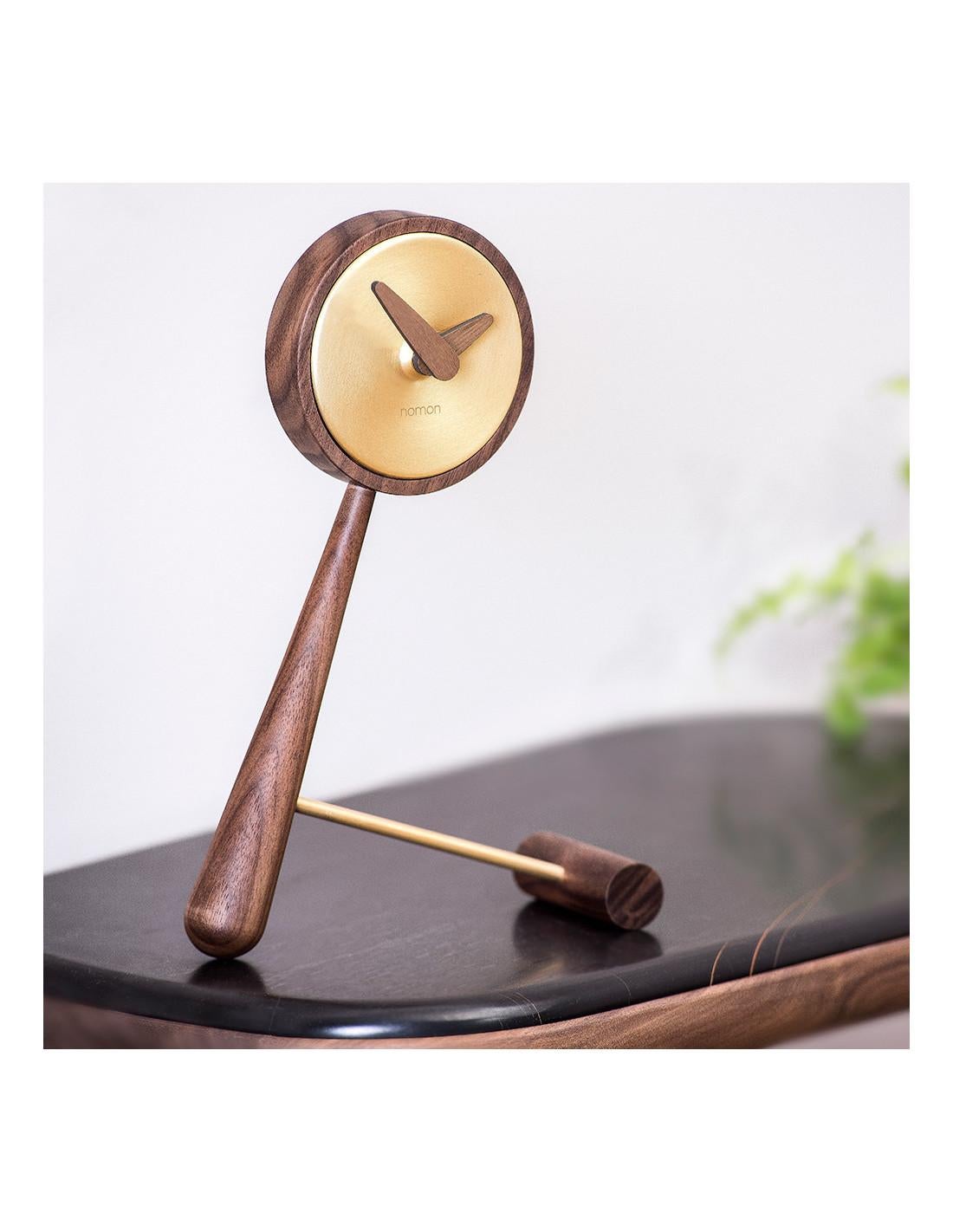 It is made with the greatest precision to represent a high-end designer clock made to turn the desktop into a true showcase where it can be seen by everyone. 
Mini Puntero G table clock : Box in polished brass, hands and body in walnut.
Each clock