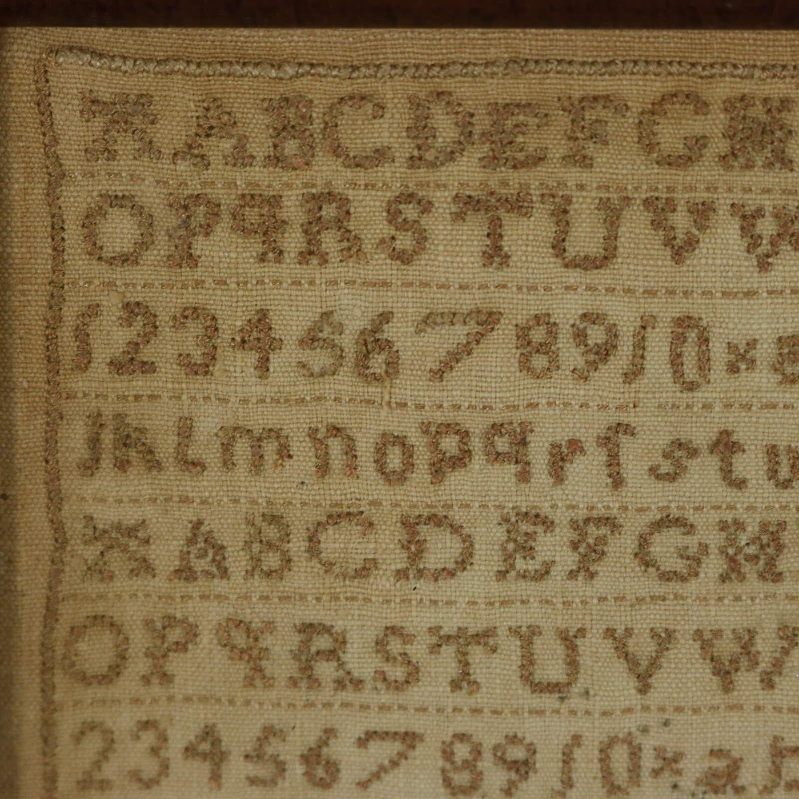 Mini Scottish Sampler, stitched in 1821, by Margaret Gibson aged 10. The sampler is worked in a brown cotton-like thread on a linen ground, mainly in cross stitch. Simple line border. Alphabets A-Z in upper case and lower case and numbers 1-10.