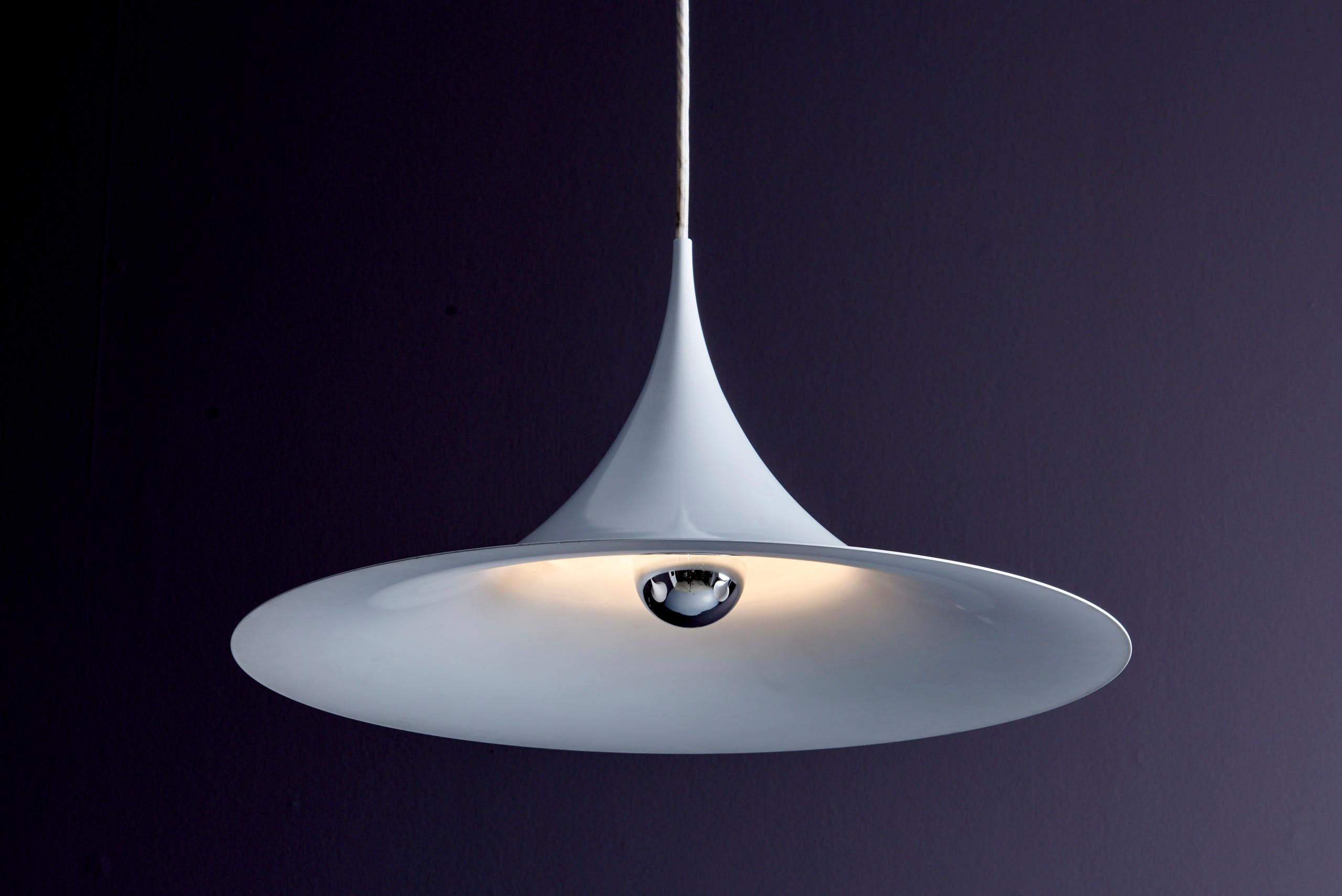 Mini Semi Pendant for Fog & Mørup. Designed by Danish architects Claus Bonderup and Torsten Thorup, the Semi pendant was introduced in 1967 as a striking counterpoint to the organic forms of the era. Its crisp, arching aluminum shade—finished in