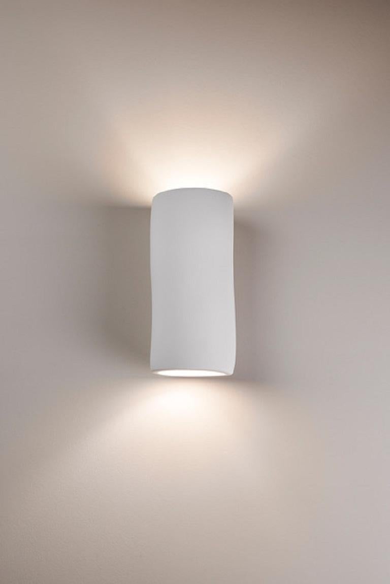 Handmade Mini Serenity wall light or sconce, in silky smooth white plaster, created by artist Hannah Woodhouse in her London studio. Contemporary design inspired by nature and mid-century European sculpture. The Mini Serenity wall sconce not only