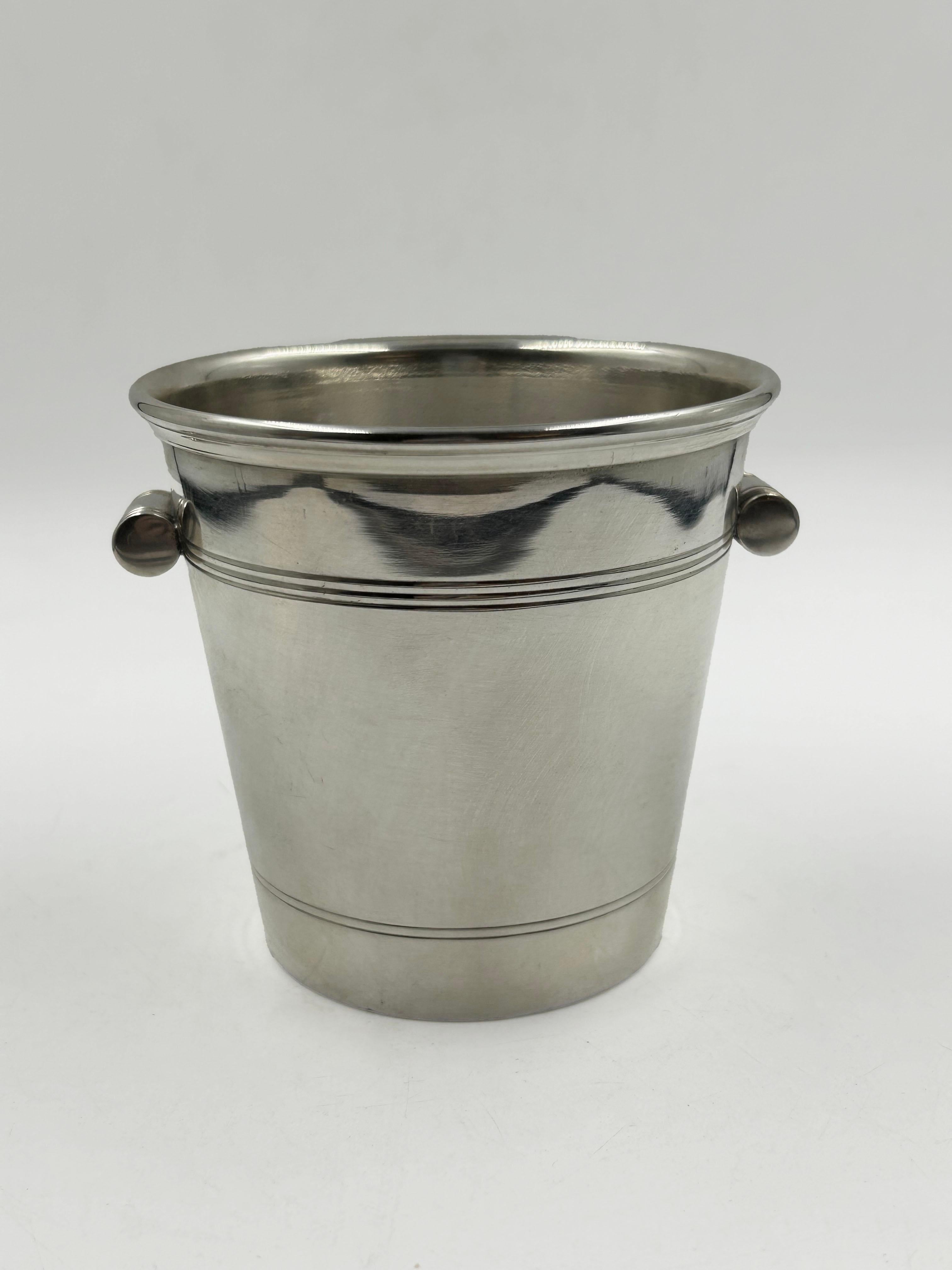 Mini Silver-Plated Ice Bucket by Cartier, 20th Century
Elegant mini ice bucket by Cartier, crafted in silver-plated metal with clean, modern lines and two rounded side handles. The piece features the refined simplicity characteristic of Cartier’s