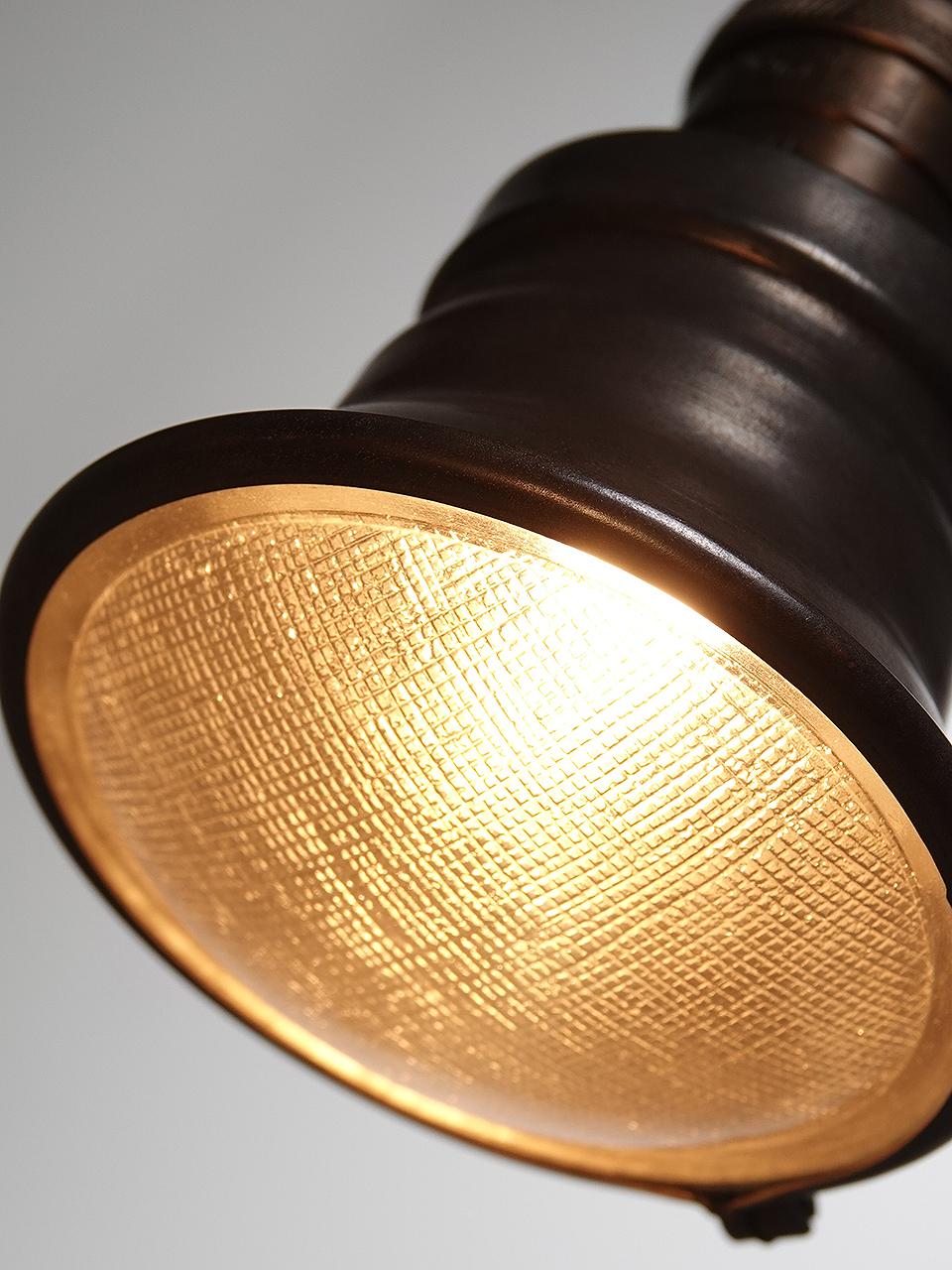 Pictured are mini spot pendants. They come in a dark brass finish. A brass ring holds a 3.75 inch textured glass lens. The look is as simple and elegant as it gets. They are priced per lamp.
