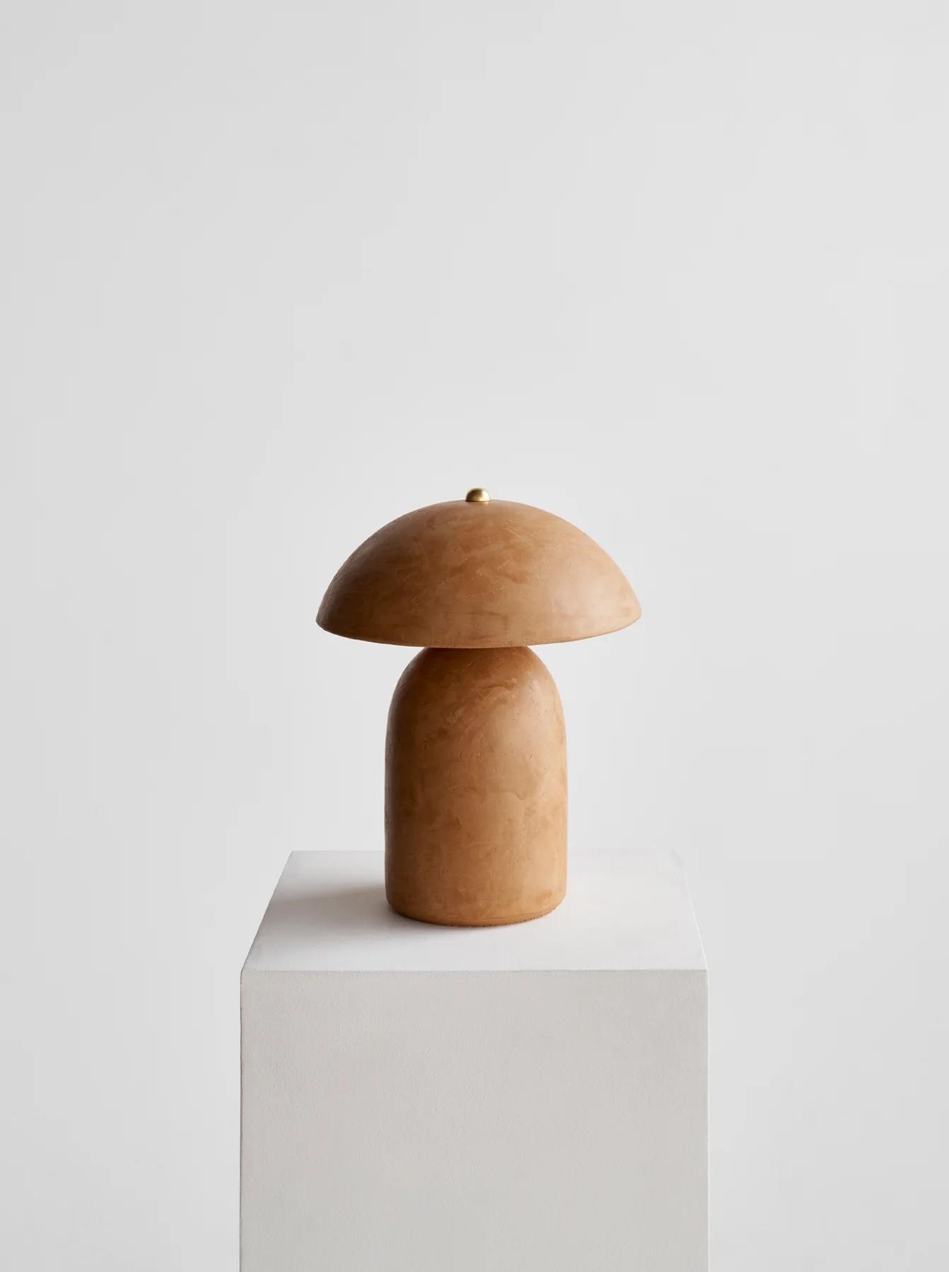 La lampe Tera - Lime Plaster de Ceramicah est composée d'un abat-jour en céramique et d'une base en céramique. Une fois les pièces en céramique passées au four, la finition en plâtre de chaux est appliquée à la main en deux couches, puis poncée et