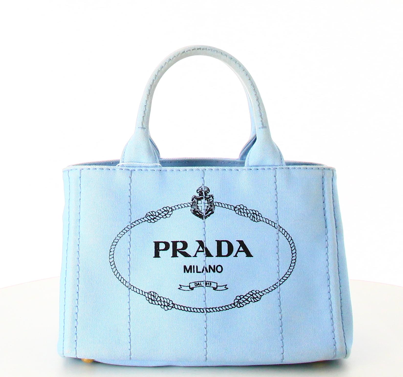 Mini Tote Bag Prada Sky Blue

- Good condition. Shows signs of wear over time.
- Prada Tote Bag
- Sky blue fabric 
- Prada logo on front 
- Two small straps plus a long shoulder strap 
- Inside: Lined fabric plus inside pockets