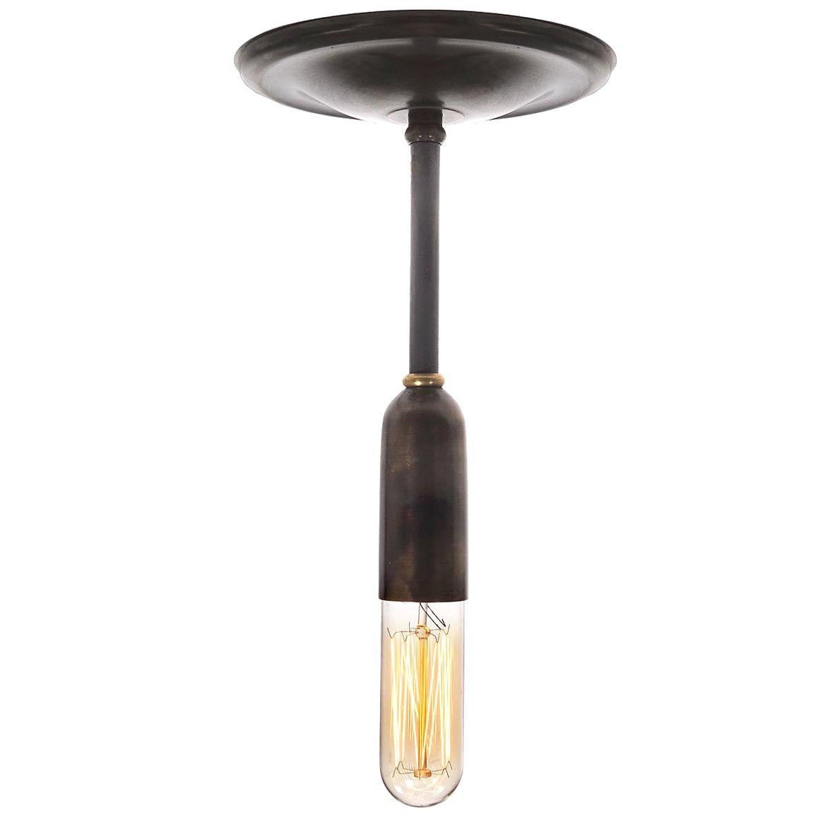 This is a very clean and simple pill shaped lamp. The lamp is half brass and half bulb on a brass rod that can created with a 3 inch to 36 inch pipe drop. Let us know the length and we will finish it to your specs. The look goes well with all