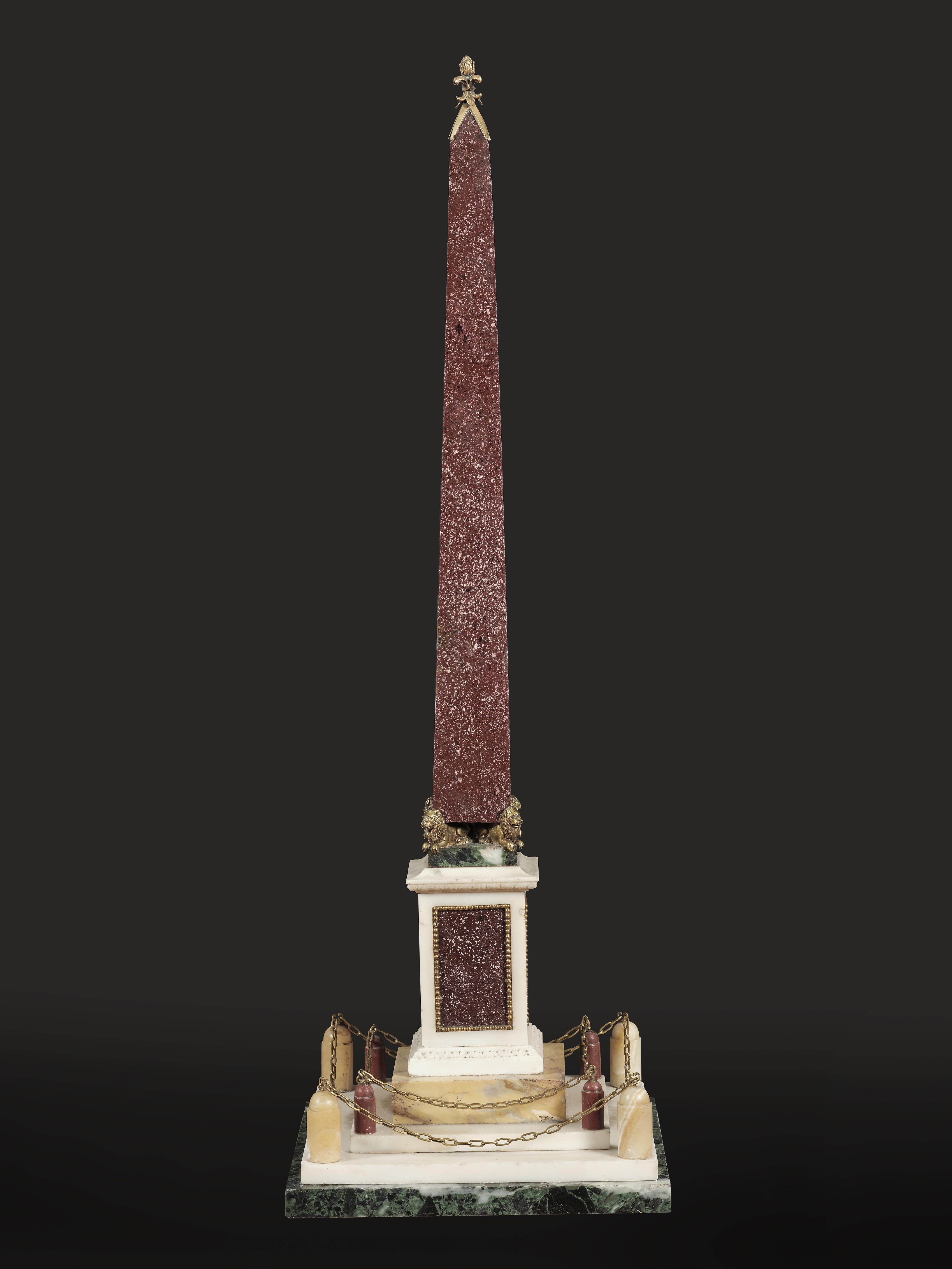 Questo magnifico obelisco, risalente al XIX secolo, è un esempio straordinario di arte decorativa dell'epoca. Segue il gusto del Grand Tour, quando miniature di grande maestria venivano realizzate come souvenirs per i viaggiatori. L'obelisco è in