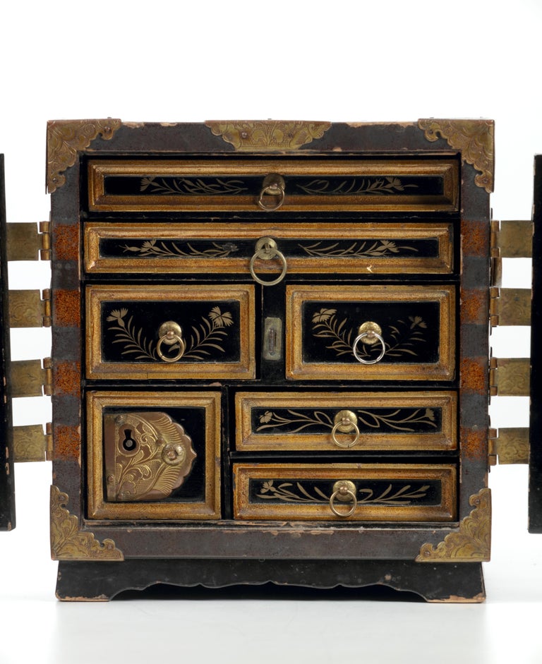 Possibly unique small cabinet
Japan, Edo period, 17th century

Black lacquered wood (Urushi), decorated with gold
lacquer (Maki-e) and gilt copper mounts.
Measures: Height 18.5 cm, width 16.9 cm, depth 16.9 cm.
Japanese lacquered cabinets