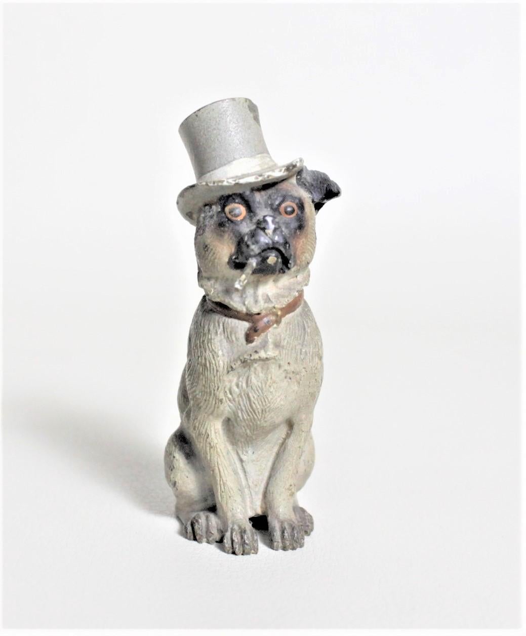 This antique cast and cold-painted bronze sculpture is unsigned but presumed to have been made in Austria in circa 1900. This well executed cast bronze study depicts a seated dog wearing a top hat and smoking a cigarette. The detail of the casting