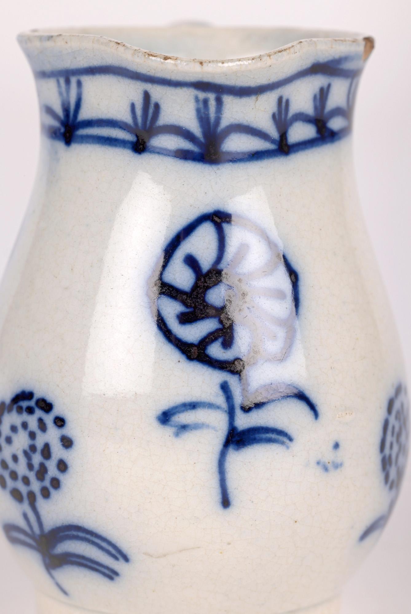 A delightful and rare antique English pearlware hand painted miniature jug dating from the latter 18th century. The bulbous shaped jug has a simple ear shaped loop handle to one side with top with a wide shaped pouring spout. The body of the jug is