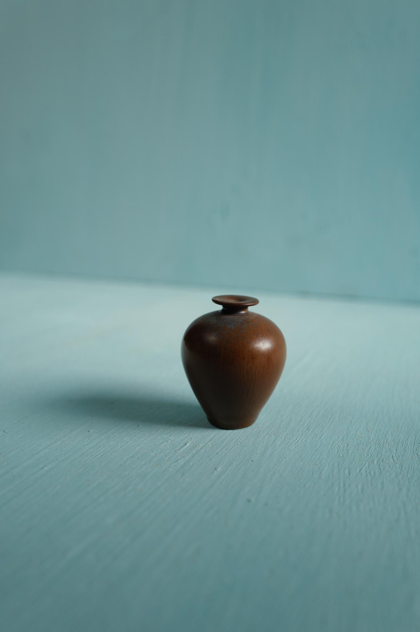 A miniature brown ceramic vase designed by Berndt Friberg, produced by Gustavsberg, Sweden 1950s.

Berndt Friberg began working at Gustavsberg in 1934, mastering both form and glaze under legends like Wilhelm Kåge and Stig Lindberg. Renowned for