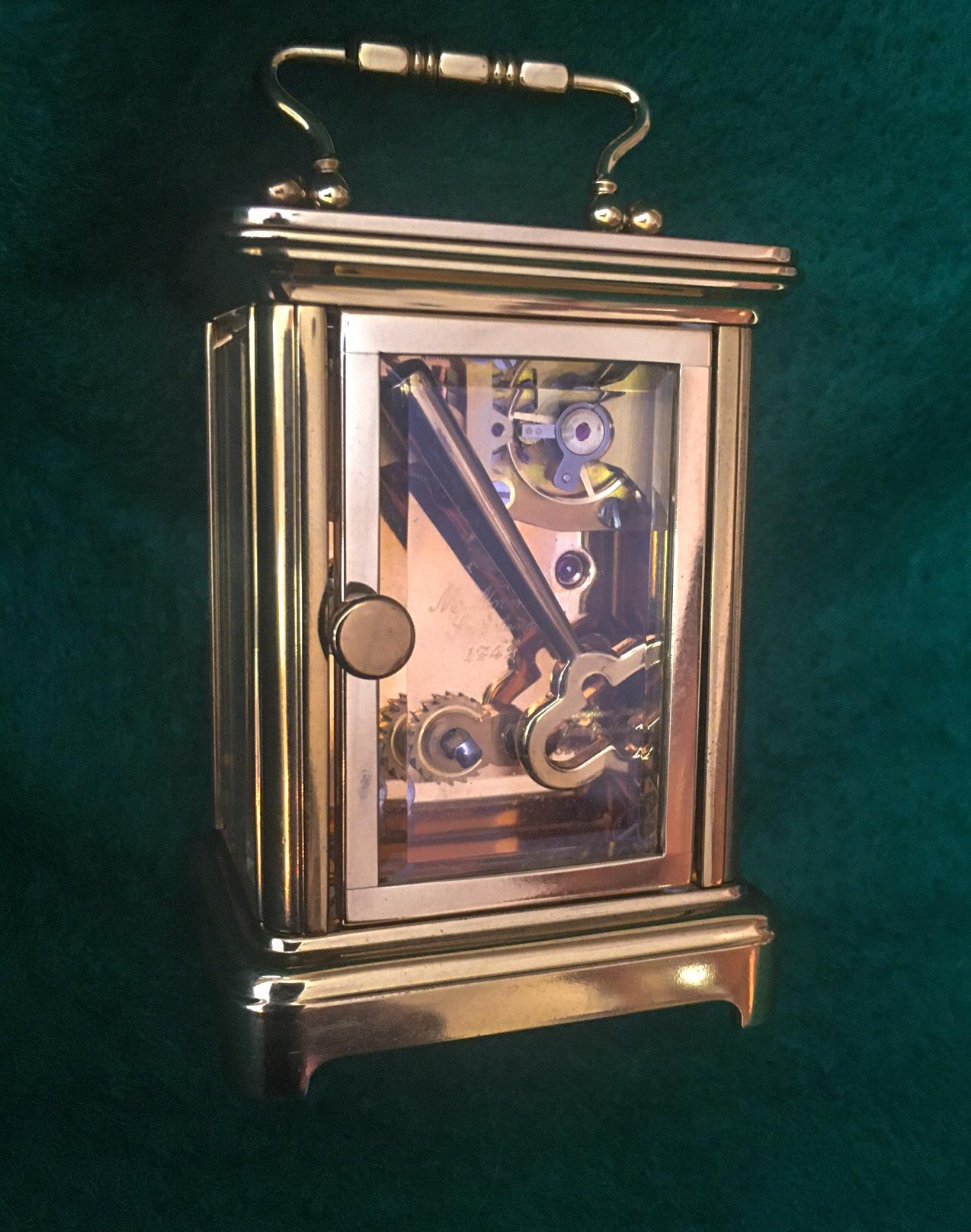 This very petite miniature carriage clock was made by Mathew Norman of
Switzerland and retains the original key.
Features include a miniature brass Corniche case with rectangular
top and folding handle over four beveled glass sides held
by plain
