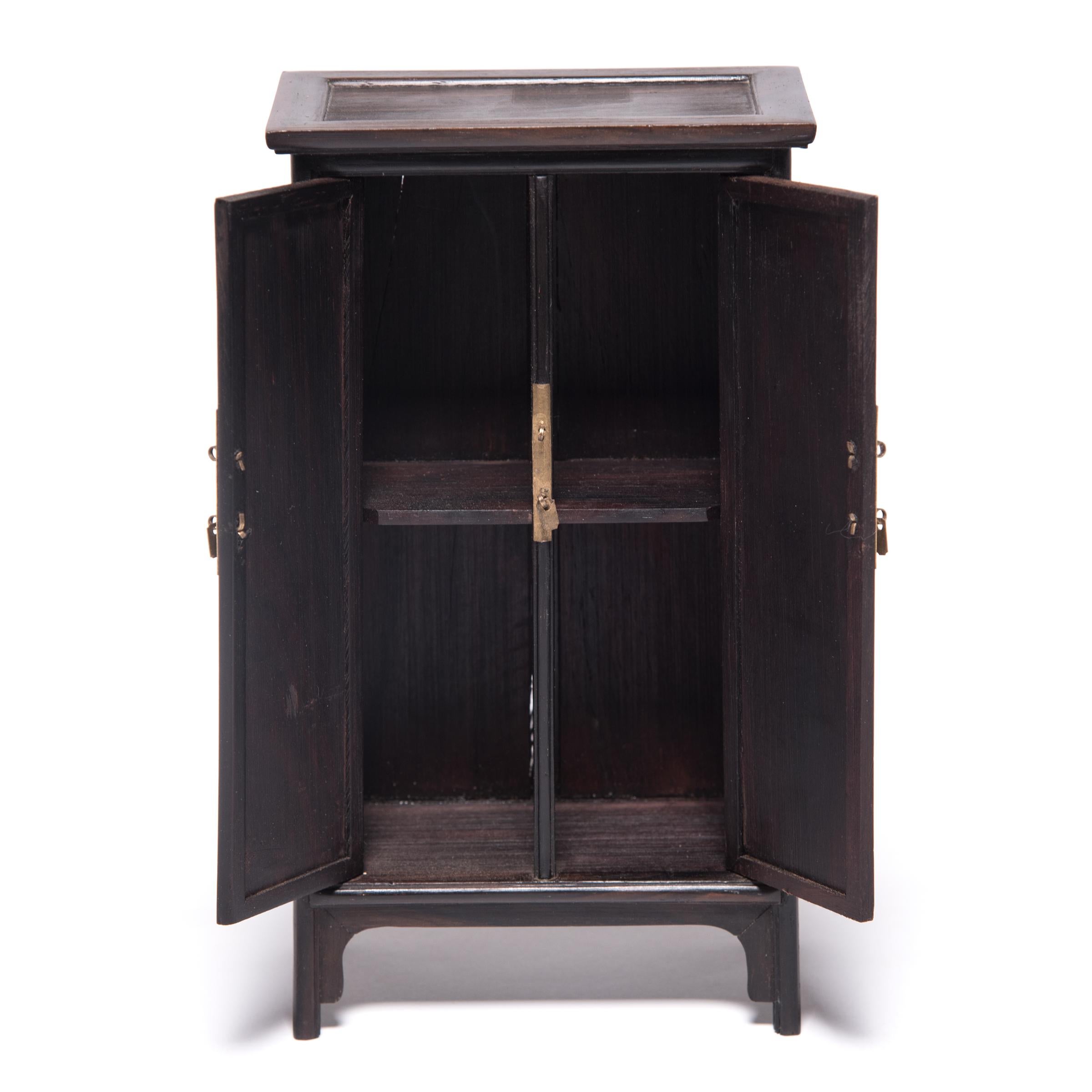A full size cabinet with this level of workmanship would be an incredible find, but this beautiful piece of furniture - at only eight inches tall - is perfectly constructed down to the tiniest minutia. The cabinet was made in northern China out of