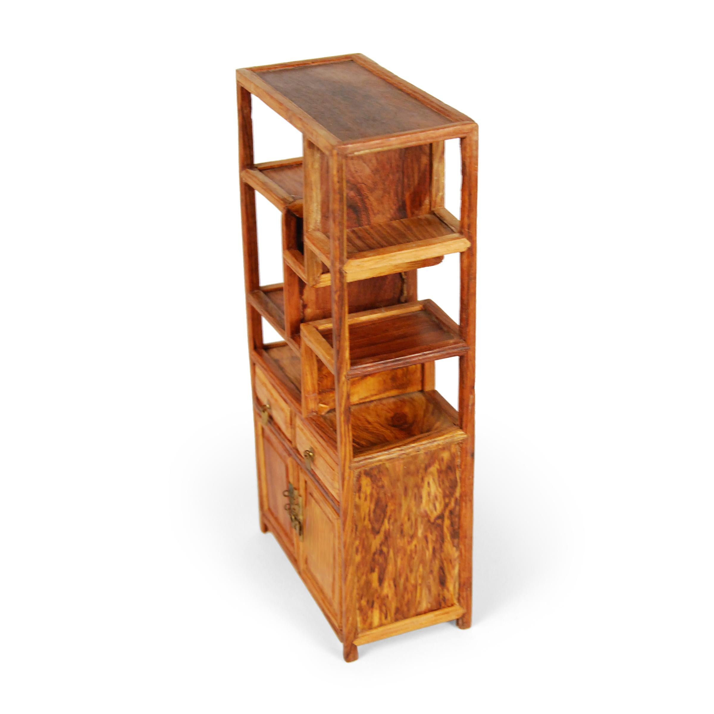 A full size bookcase with this level of workmanship and detail would be an incredible find, but this beautiful piece of furniture—at only eight inches tall—is perfectly constructed down to the tiniest minutia. Crafted of a warm hardwood, the small